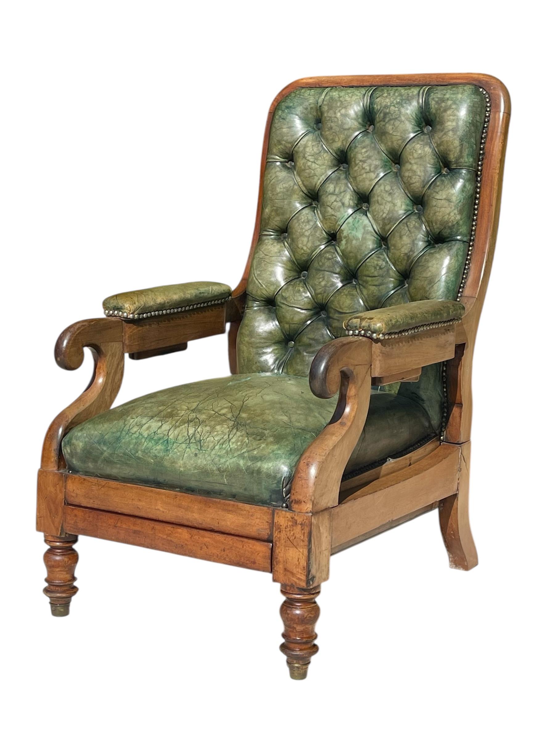 Superbe fauteuil Chesterfield en acajou massif et cuir vert. Le dossier s'incline grâce à des loquets situés sous les accoudoirs. Il y a également un plateau coulissant sous le siège, qui sert de repose-pieds. Ce fauteuil confortable vous permet de