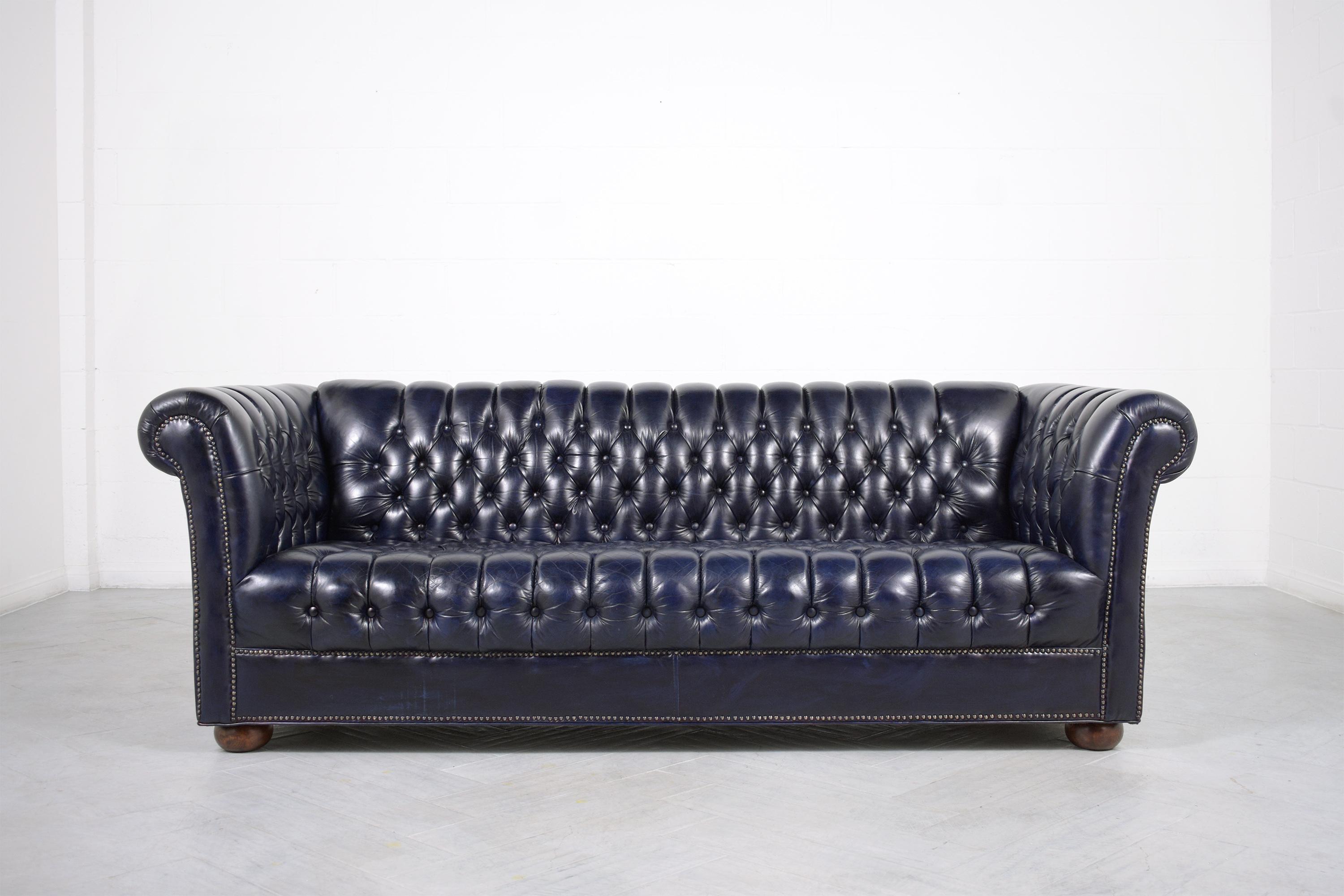 An extraordinary vintage navy blue leather tufted chesterfield sofa in great condition is crafted out of solid wood and leather combination completely restored by our professional craftsmen team and has been newly dyed in a custom-made navy blue