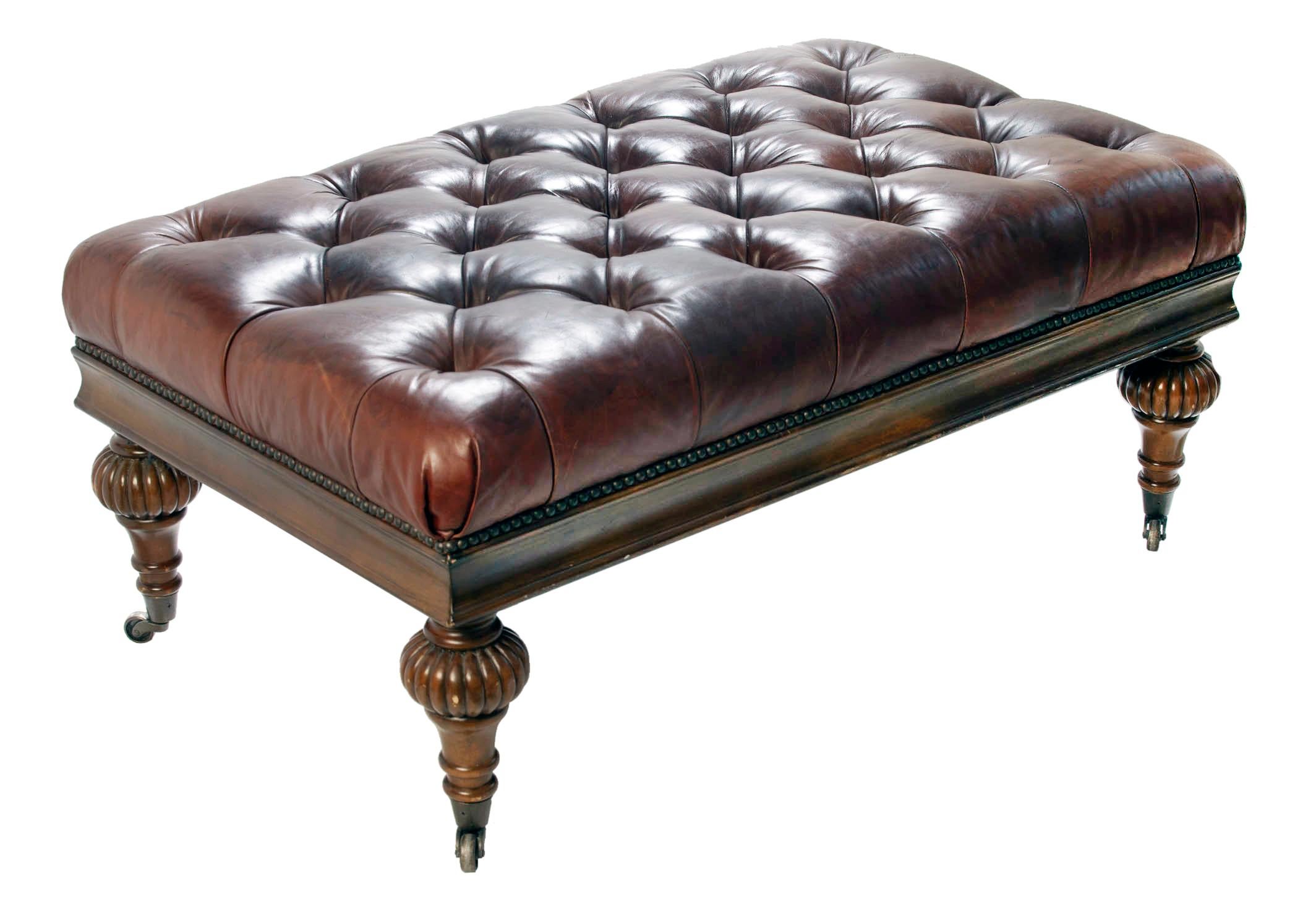 Chesterfield style leather ottoman on traditional turned legs finished with petite brass casters.