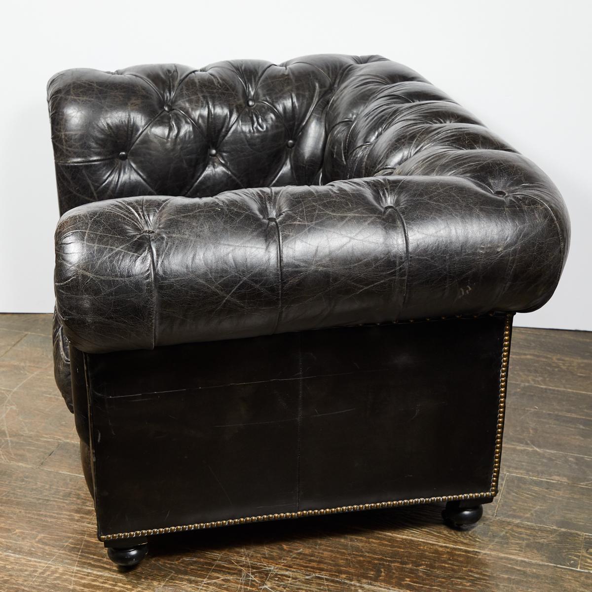 Chesterfield oversized tufted armchair in original black leather. Classic Chesterfield curved arms and wide seating.