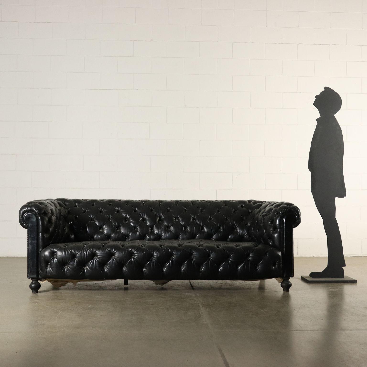 Chesterfield sofa, black leather. Turned carved and ebonized feet. Manufactured in Italy, first half of the 20th century.