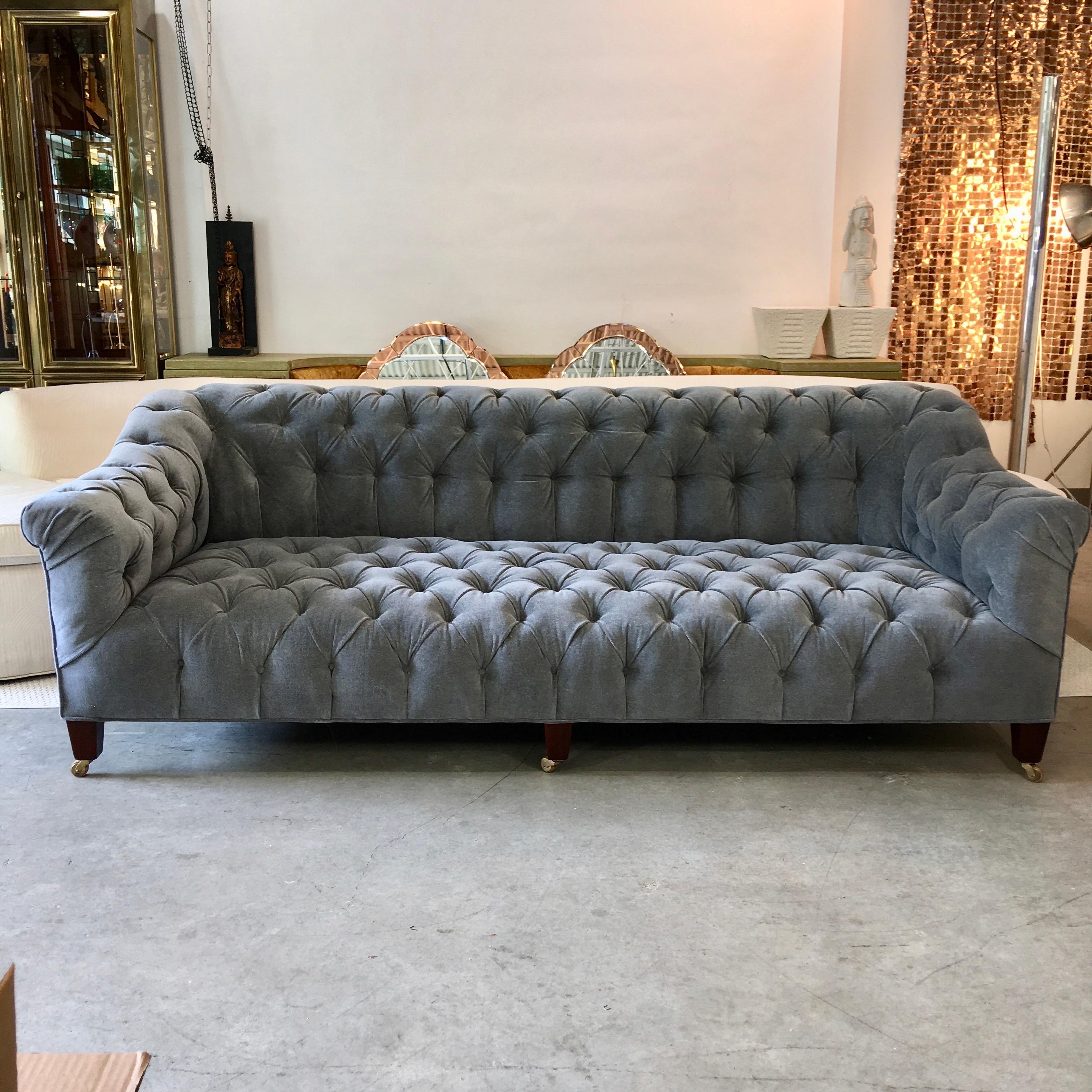 Late 19th century Chesterfield club sofa on six tapered block mahogany legs with brass casters with wooden wheels, newly reupholstered in luxurious grey mohair with deep button tufts.
They don't make them like this anymore! This solidly built sofa