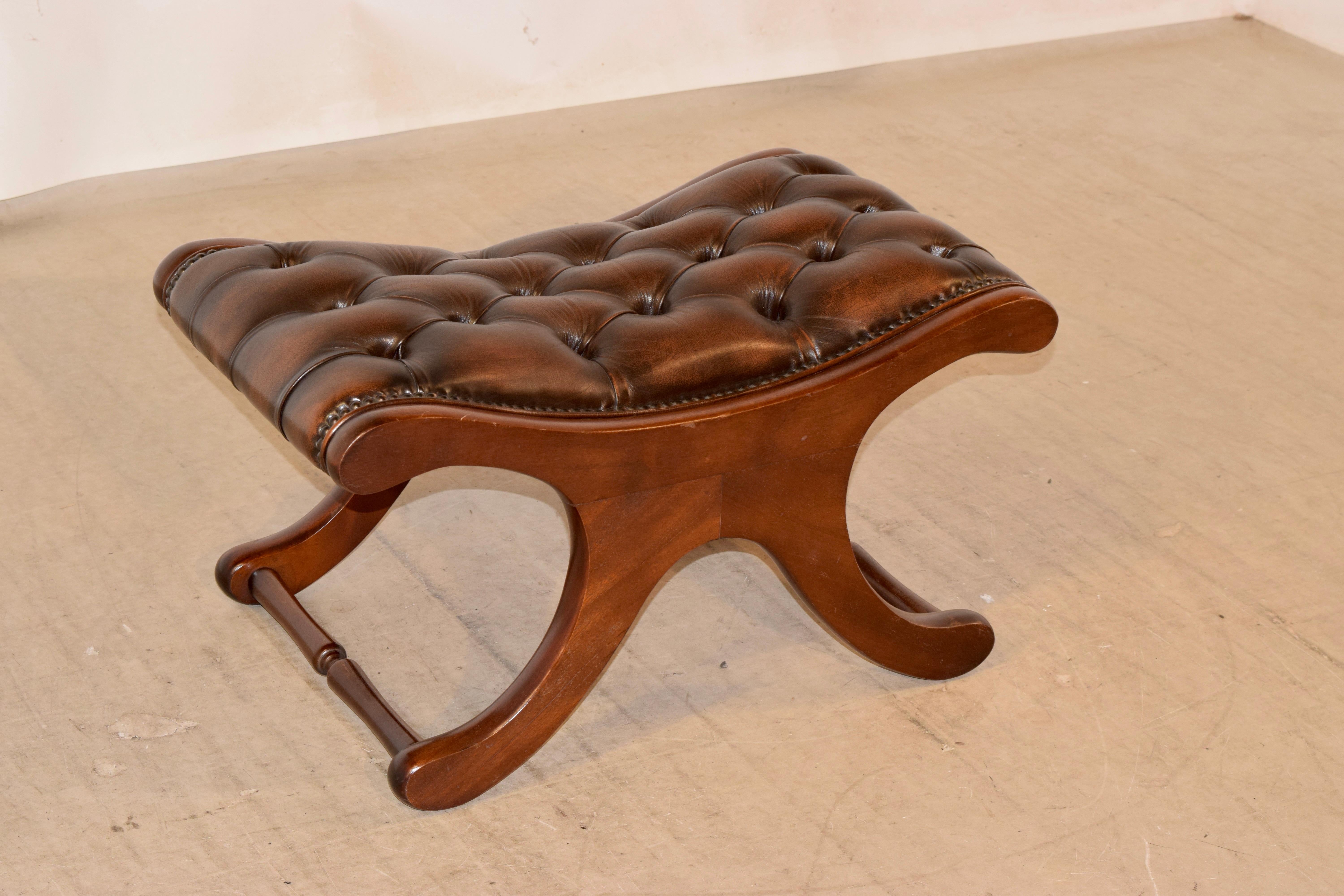 English mahogany stool with a Chesterfield upholstered leather top in rich brown with leather welt decoration, circa 1920.
      
