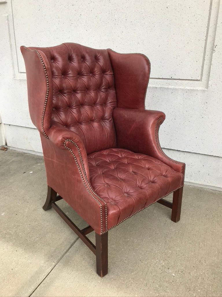 A handsome and very comfortable 19th century English walnut Chesterfield wingback chair re-upholstered in buttoned burgundy leather with brass studs. This chair has a wonderful profile, and, most importantly is a pleasure to spend time sitting in.