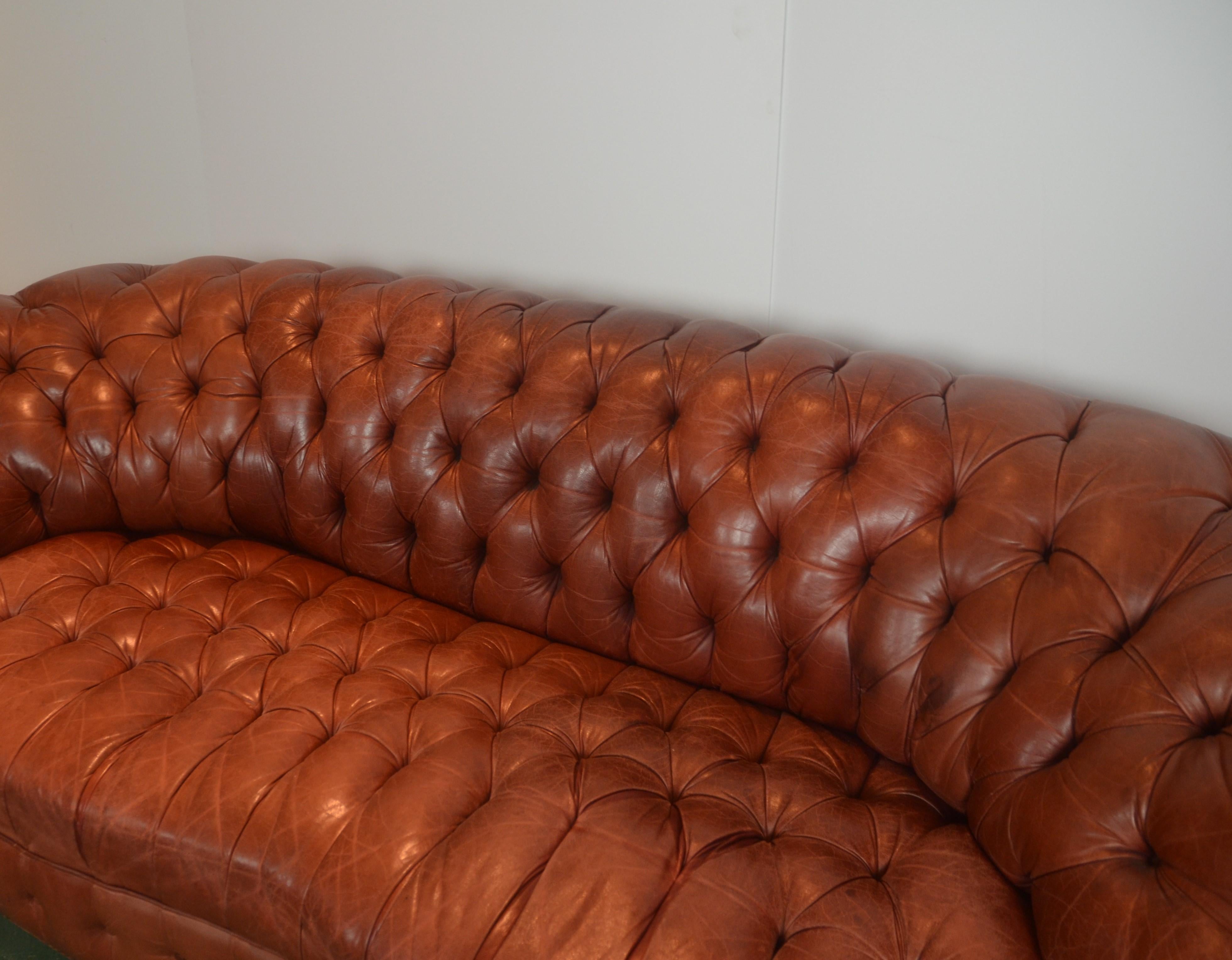 Chesterfield cigar sofa with harmonious curves, soft leather, firm stuffing, and unmissable round head nails and bun feet.