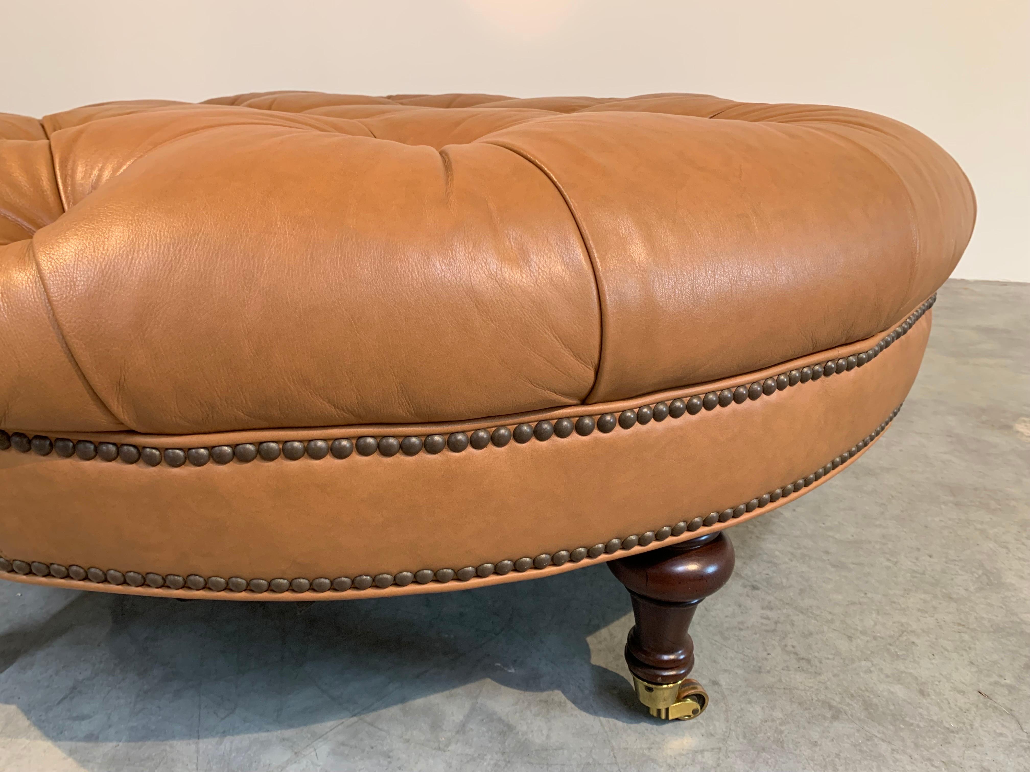 Pearson Collection 117 Paula Cocktail Ottoman. 
 Hand-tufted with hand turned maple legs that are fitted with Antique Brass casters having beautiful, supple leather that is in perfect condition. 
Meausres: Height is 18” with a Diameter of