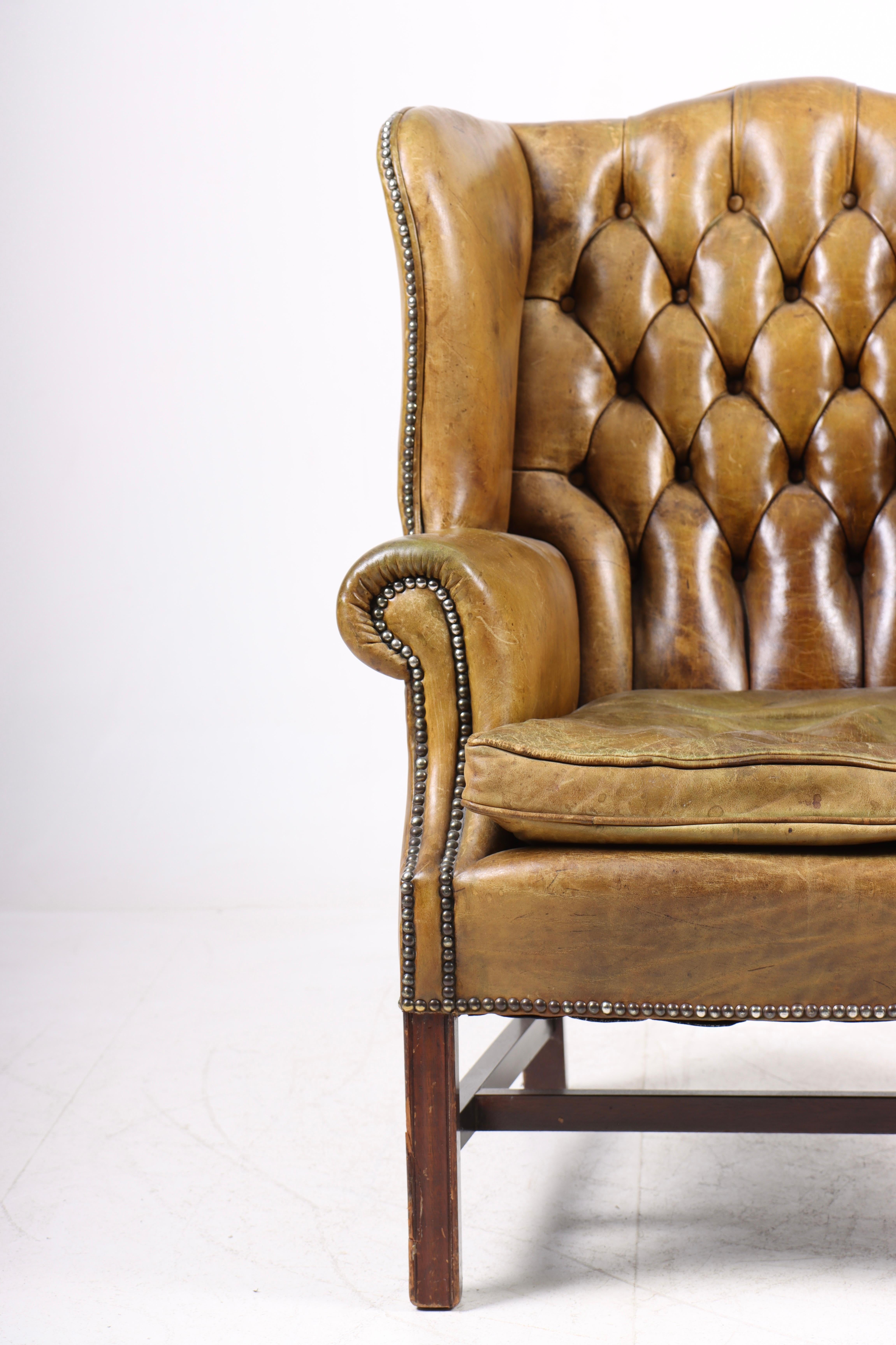 Great looking wingback chair in patinated leather. Designed and made in Denmark 1950s.