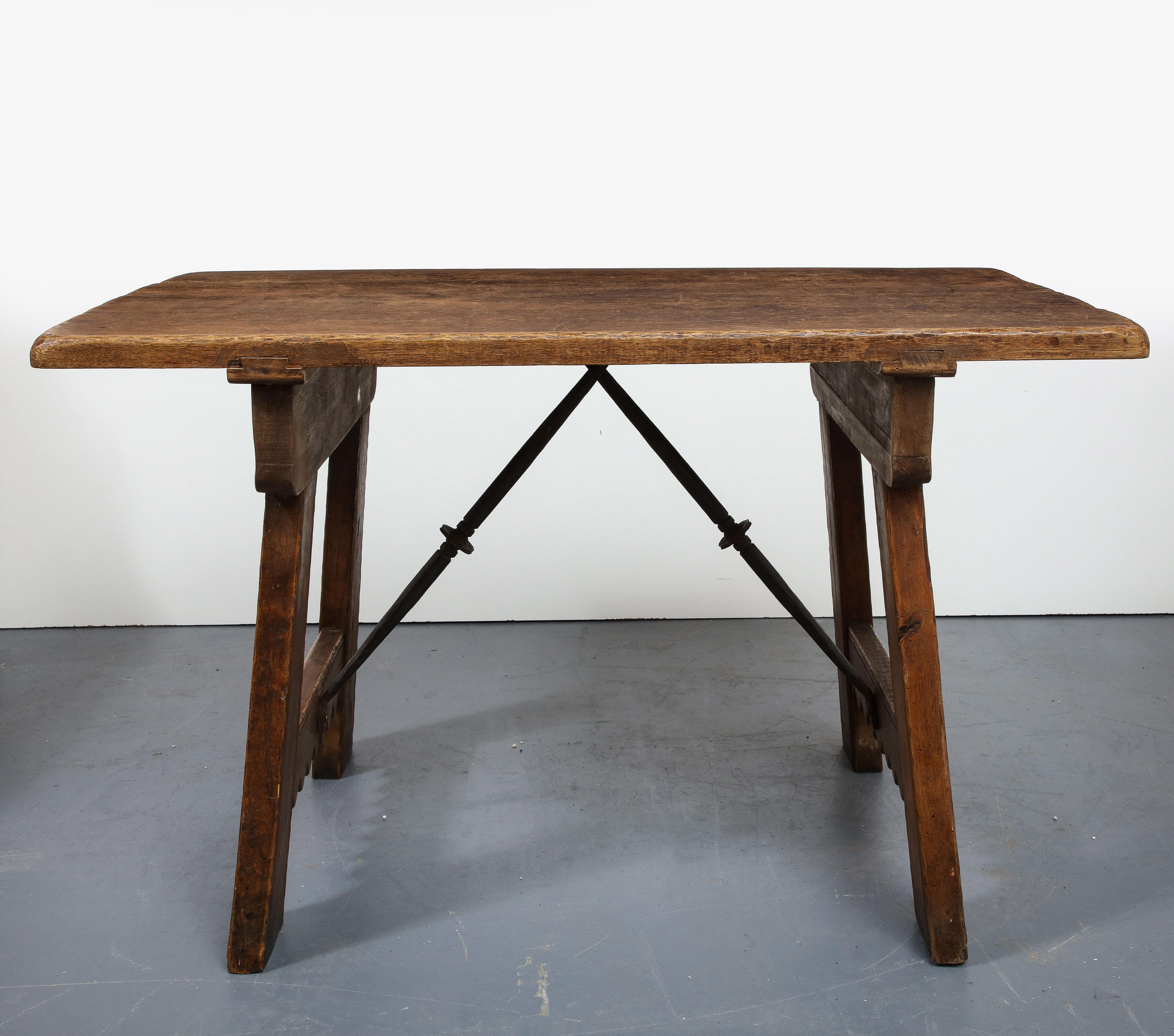 Chestnut and elm table, Spain, circa 1910. 

Rustic, storied table with exceptional construction and beautiful hard-carved details.