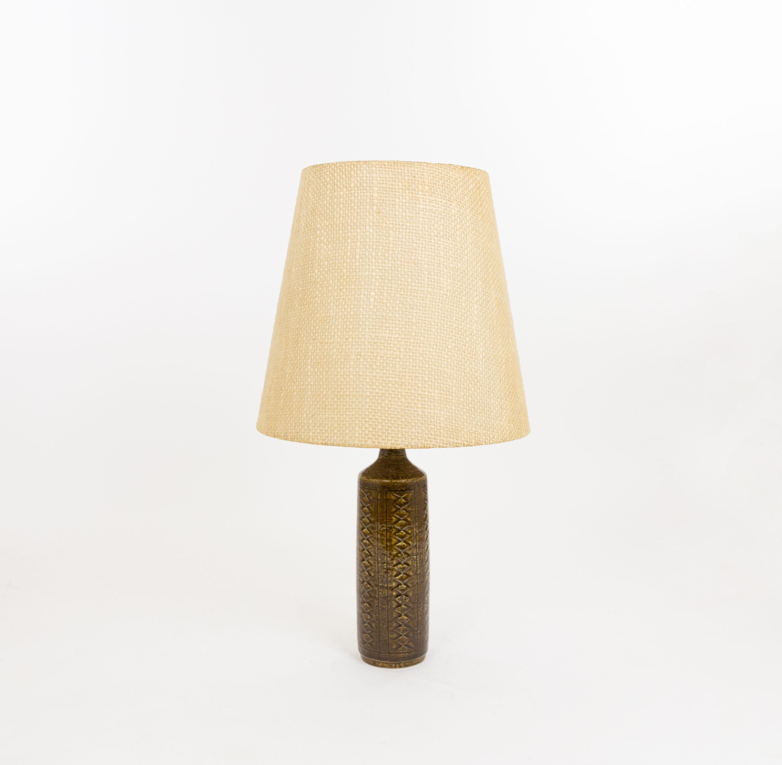 Lampe de table modèle DL/27 réalisée par Annelise et Per Linnemann-Schmidt pour Palshus dans les années 1960. La couleur de la base décorée à la main est Chestnut Brown. Il présente des motifs impressionnés.

La lampe est livrée avec son support
