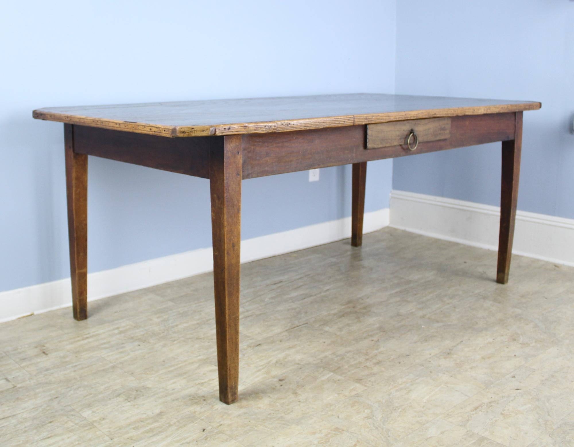 An unusual and exciting chestnut farm table with canted corners and a contrasting decorative edge. We have never had a table like this! The chestnut has glorious glowing patina and rich color. Single drawer with divided space. A great look! A 24