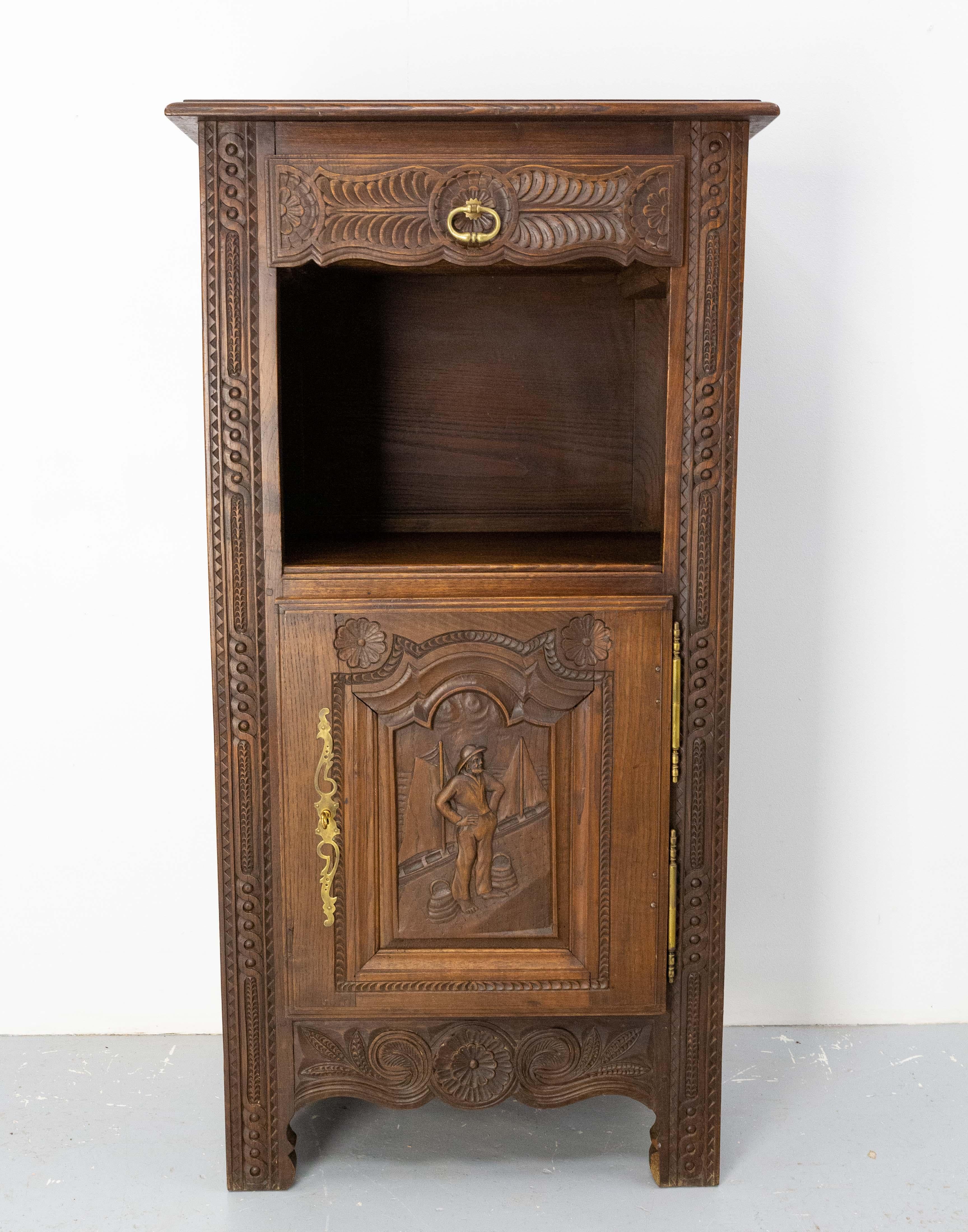 Chestnut little buffet or side table. 
This cabinet is carved with motifs and a typical scene of Brittany in France. On the door a sailor in a port awaits the ships of the fishermen to supply them with water. Behind him two fishing boats are