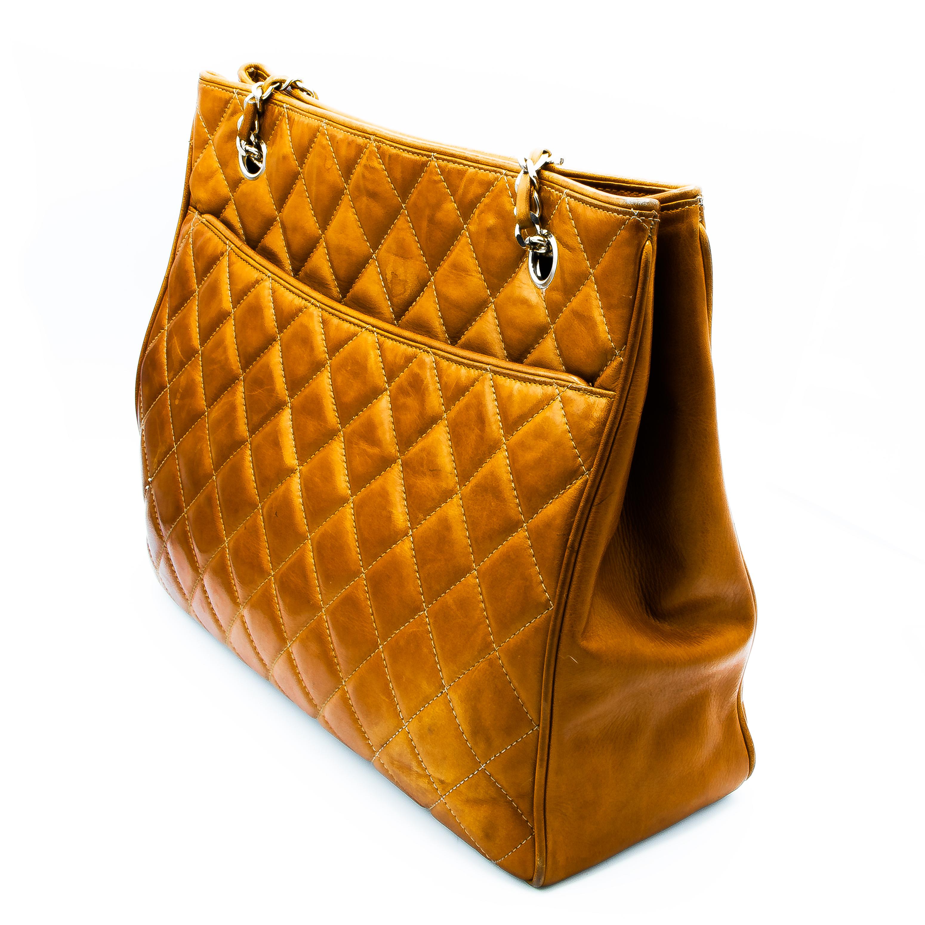 Chestnut Leather hand bag with 2 external Pockets, and 2 internal zippered pockets. This bag also has yellow gold colored hardware and leather and yellow gold colored chain straps. With button closures, this bag can be safe and secure as well as