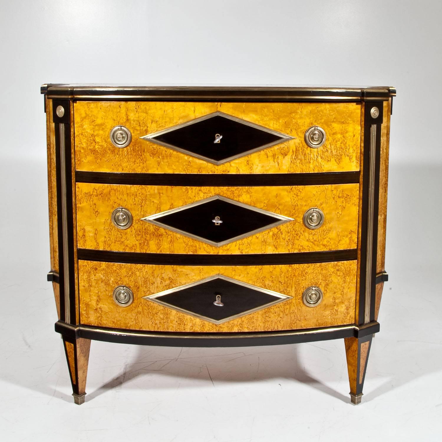 Chests of drawers of the second half of the 20th century, in the style of the 1800s. The Russian-style chests have three drawers, a trapezoidal corpus with concave sides and ebonized diamond-shaped details with brass framing. The veneer is Karelian