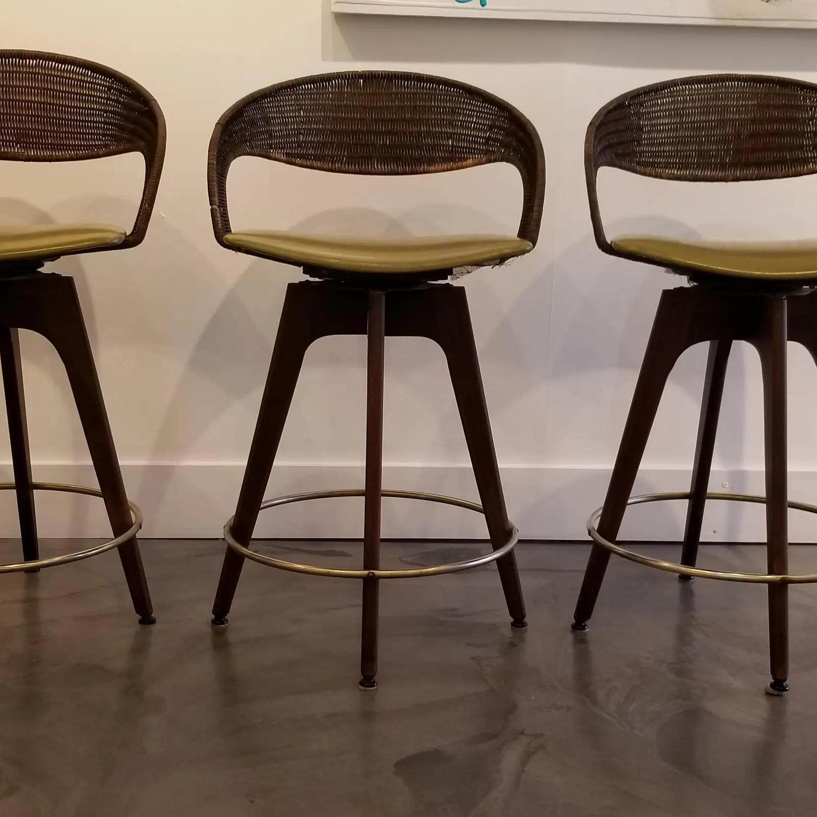Set of 3 Steel, iron, walnut, rattan and vinyl Mid-Century Modern bar stools designed by Chet Beardsley, circa 1960s. In very good original, vintage condition with light, age appropriate wear. Seating and back rests structurally solid. Original
