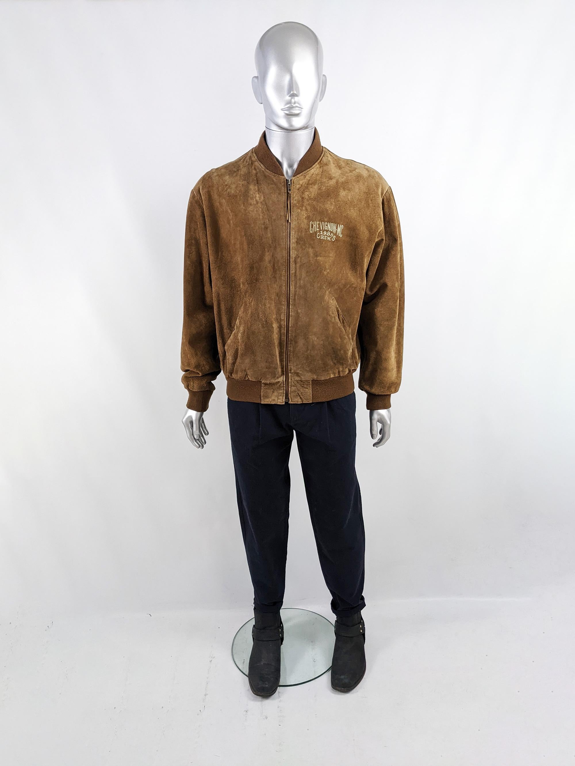 An excellent vintage mens suede jacket from the 80s by cult French designer label, Chevignon. In a luxurious brown suede with spellout embroidery on the front in an aviator style. It has ribbed knit cuffs, hem and collar and a zip front.

Size: