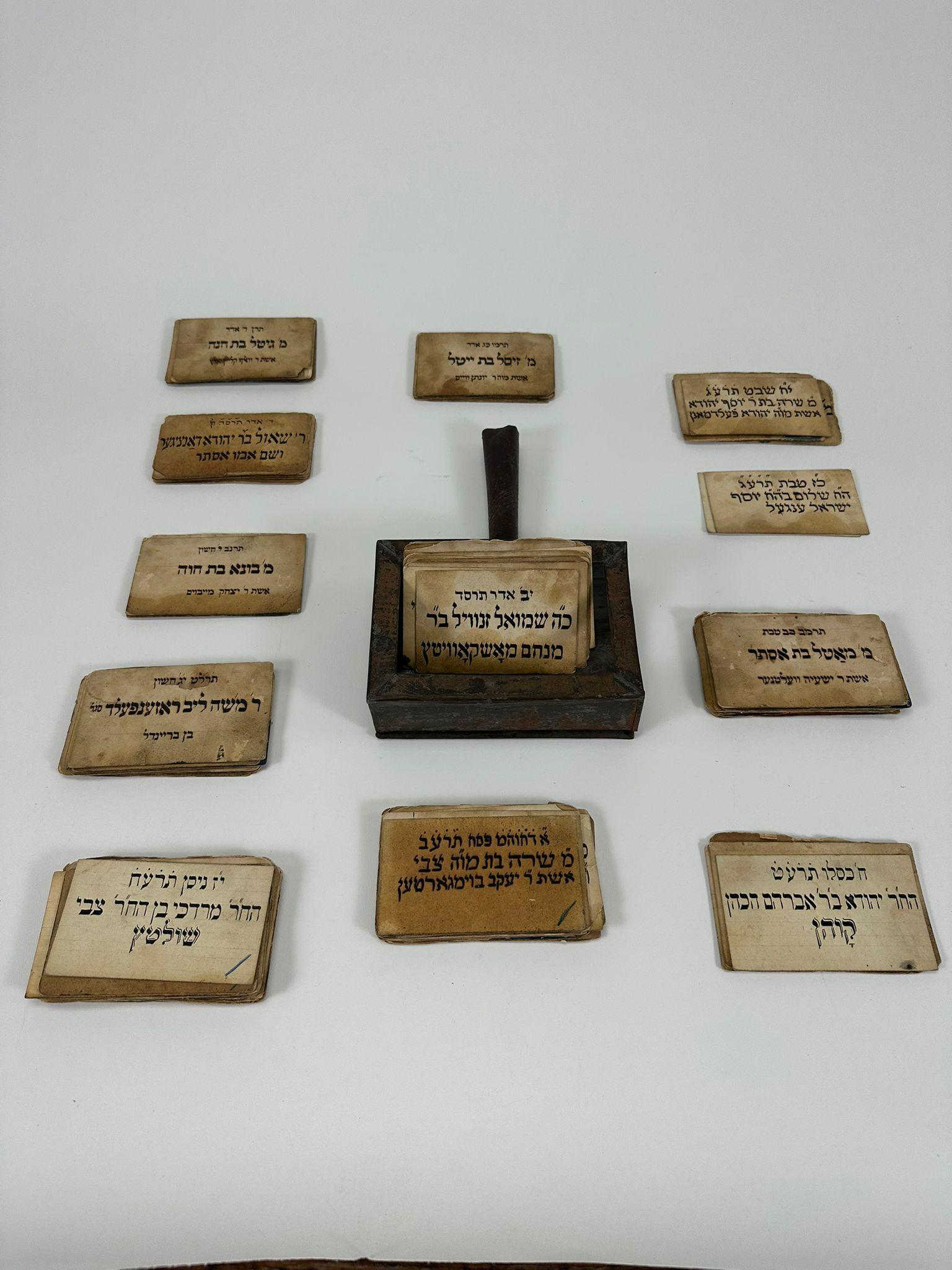 Cette rare collection de cartes commémoratives de la Chevra Kadisha (société funéraire juive), datant de 1880, provient de Budapest. Ces cartes manuscrites et imprimées, conservées dans leur boîte en fer d'origine, commémorent les noms et les dates