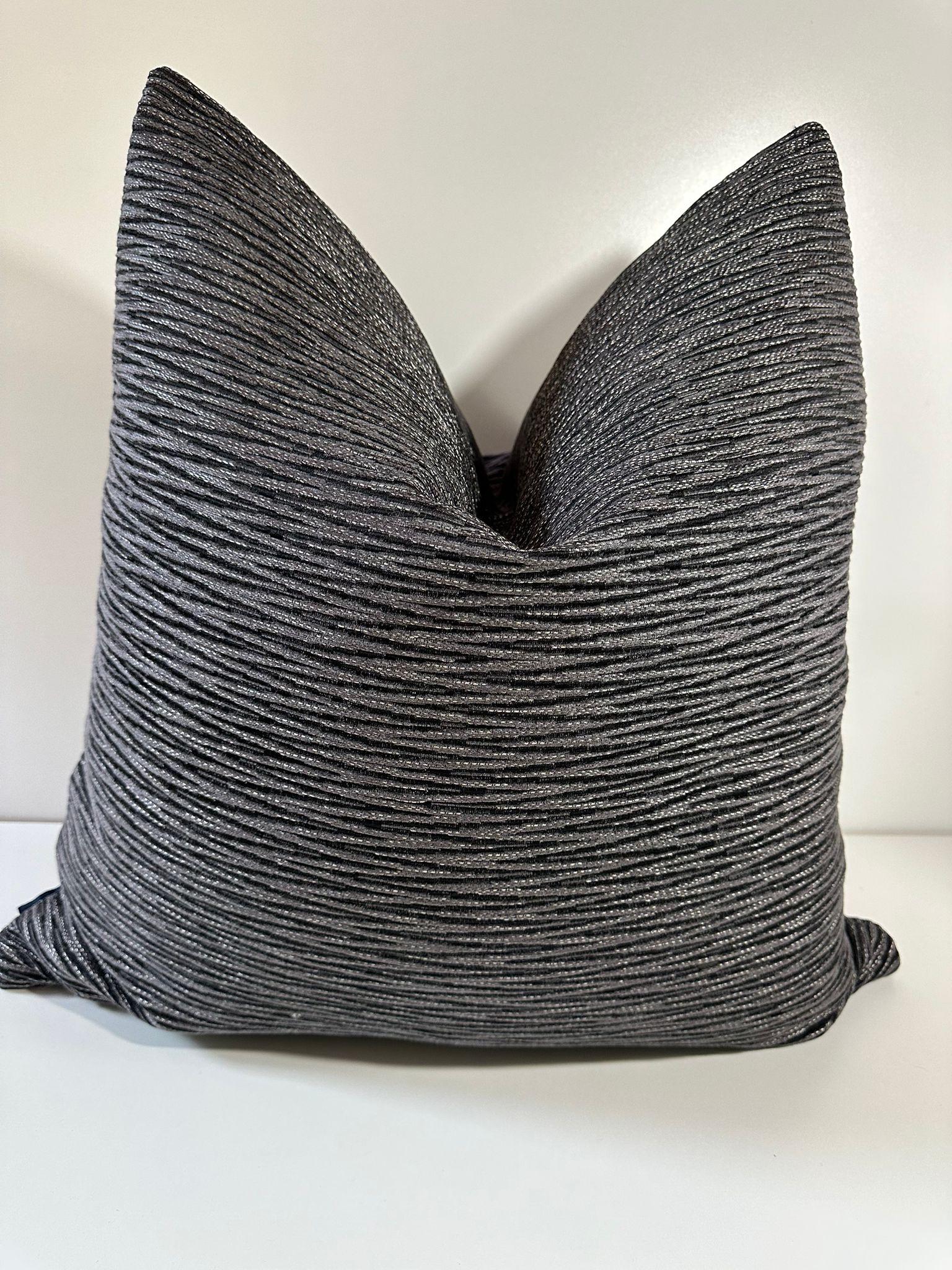 Crafted with imported fabric, this pillow features an exquisite chevron pattern that effortlessly blends different shades of black and gray, creating a stunning visual texture that captivates the eye with a slight metallic glimpse. What sets this