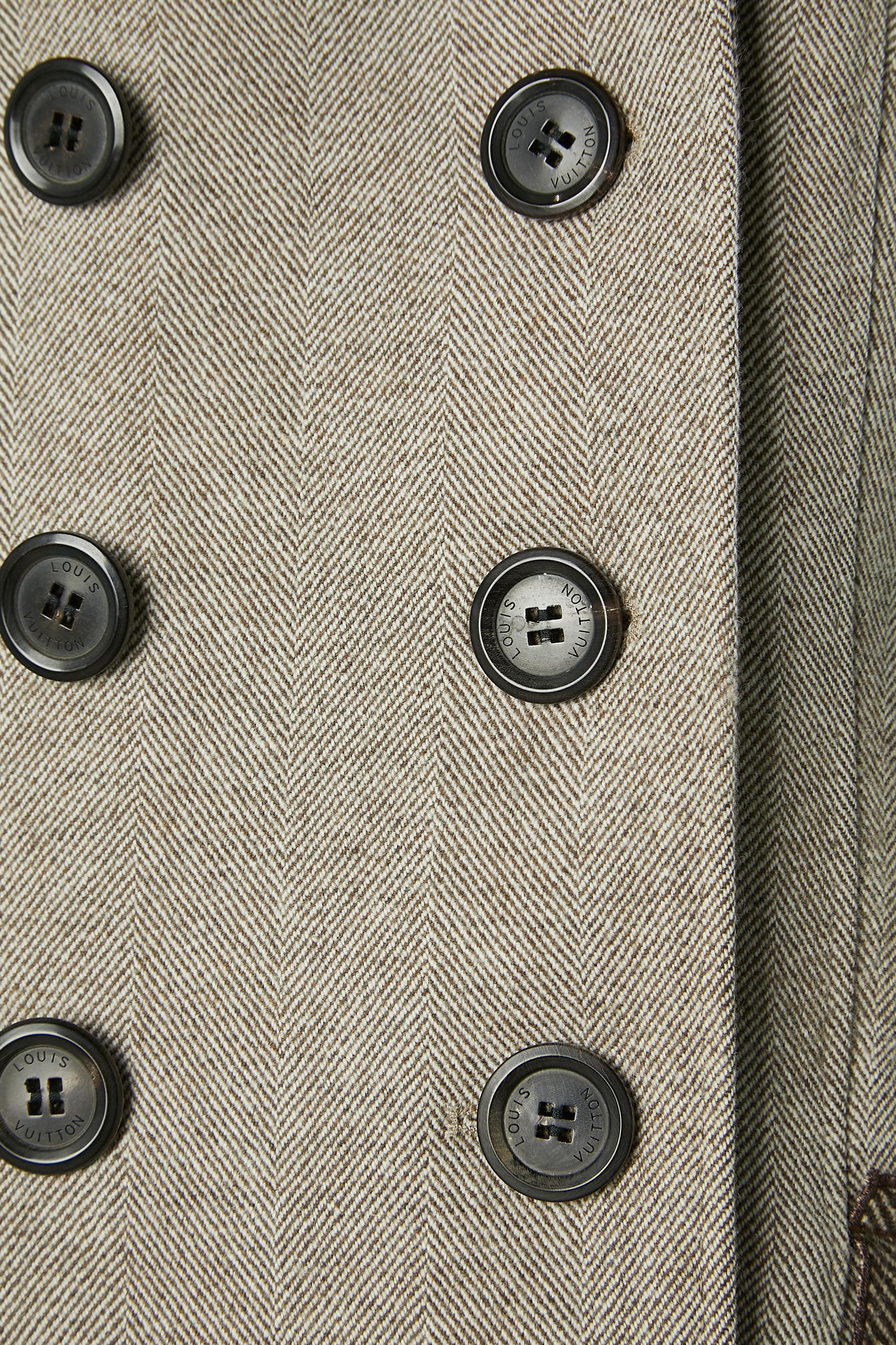 Combinaison jupe à double boutonnage avec volants. Composition du tissu principal : 90% laine, 10% cachemire. Doublure : 85% coton, 15% laine. 2ème doublure : soie. Boutons et boutonnières marqués sur le devant et sur les poignets. 2 boutons