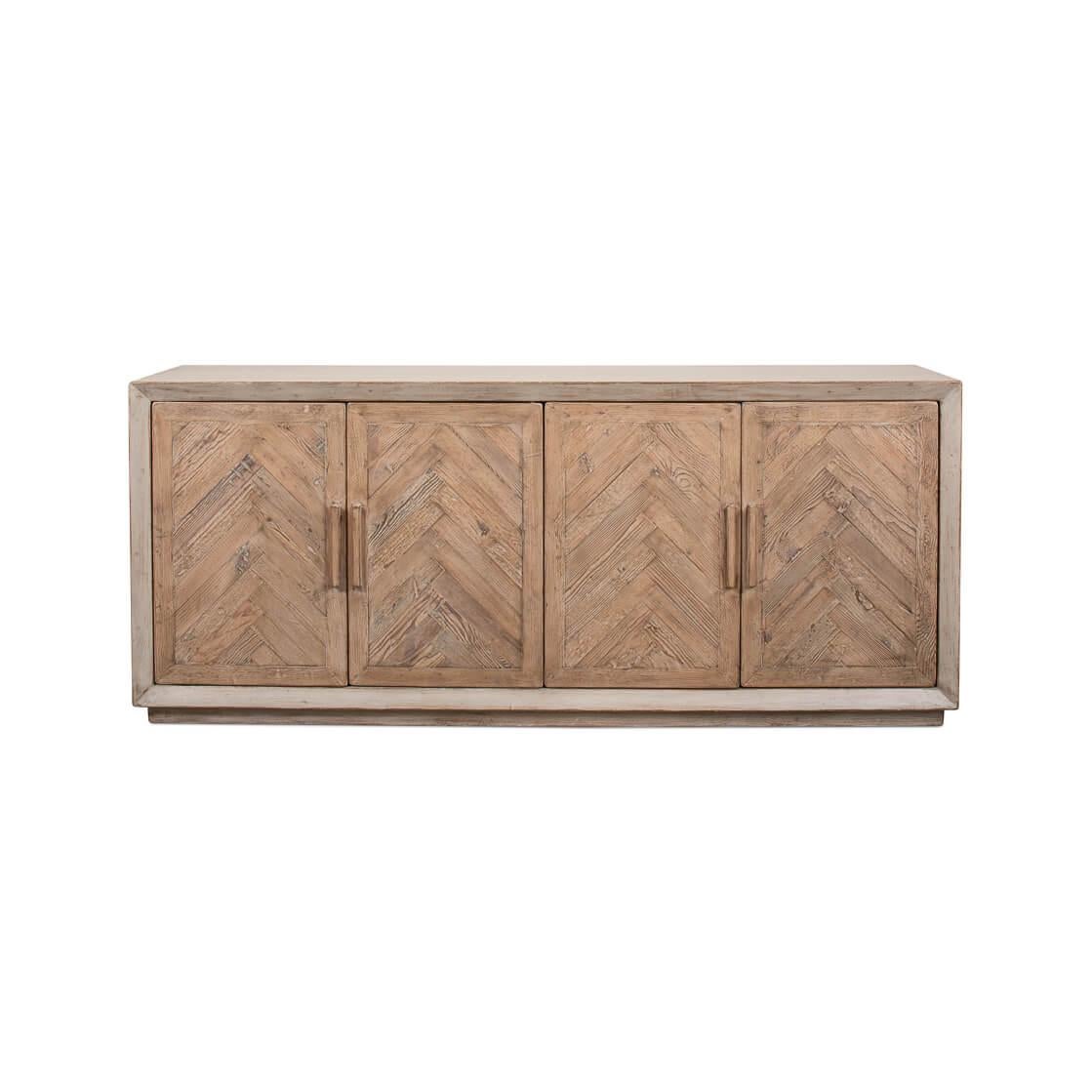 This cabinet showcases the natural allure of reclaimed pine, finished by hand in a nuanced Stone Grey that tells of whispered elegance and earthy charm. Its doors, graced with a chevron pattern, open to a world where your treasures are kept safe and