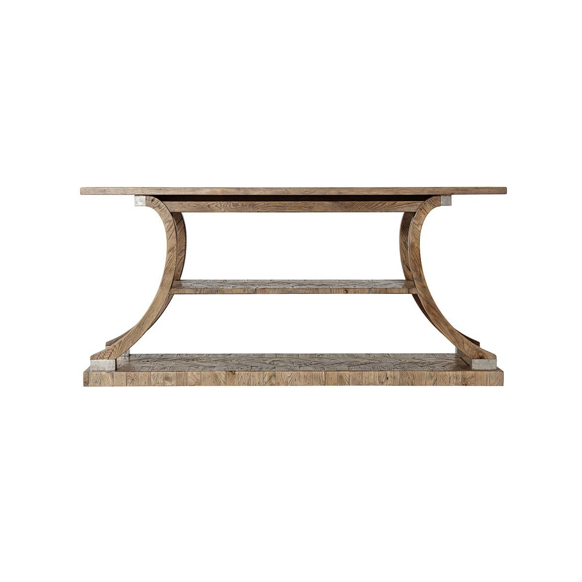 A modern rustic parquetry inlaid console table in a light echo oak finish with a chevron inlaid parquetry top, above a unique multi-tier base with inswept legs raised with vintage metal mounts on an inlaid plinth base.

Dimensions: 68