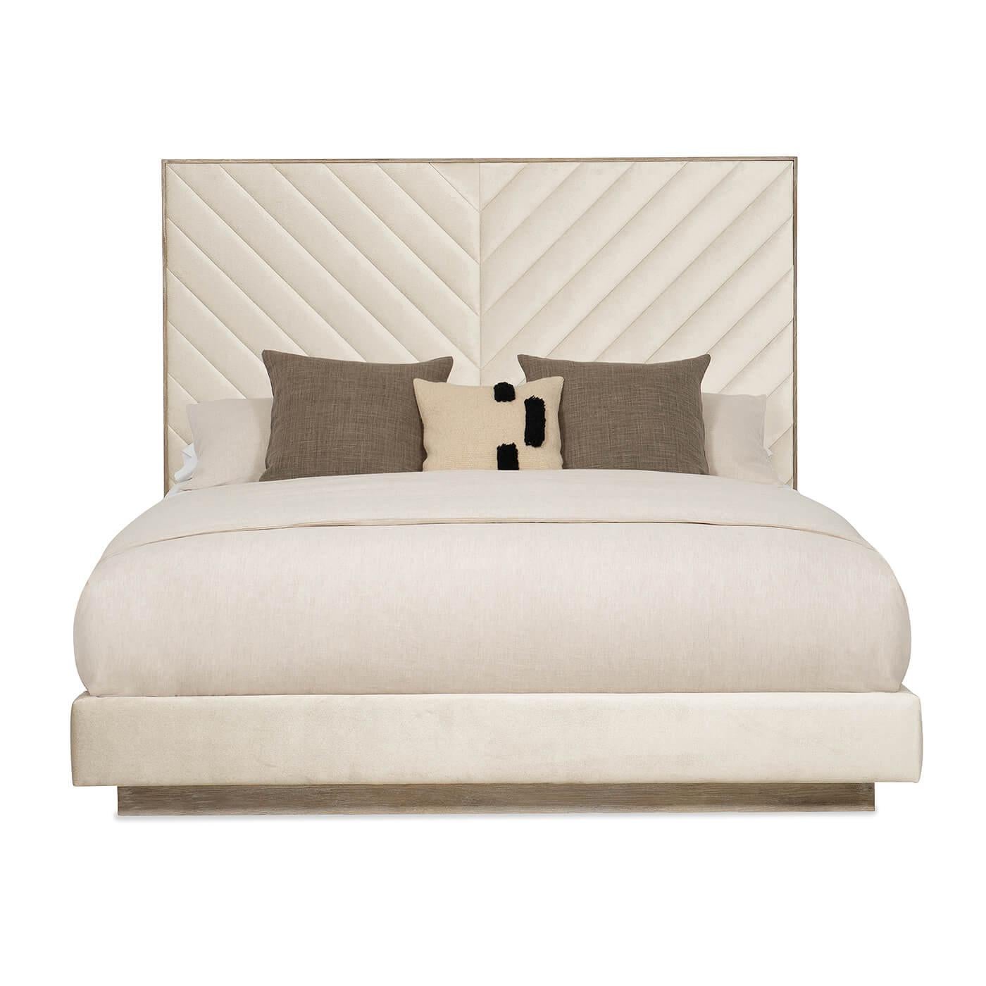 A Chevron tufted upholstered king bed with an Ash Driftwood finish frame. It has a tall upholstered headboard with a modern channel tufting design of converging angles that meet in the center to create a mesmerizing chevron. This bed’s fully