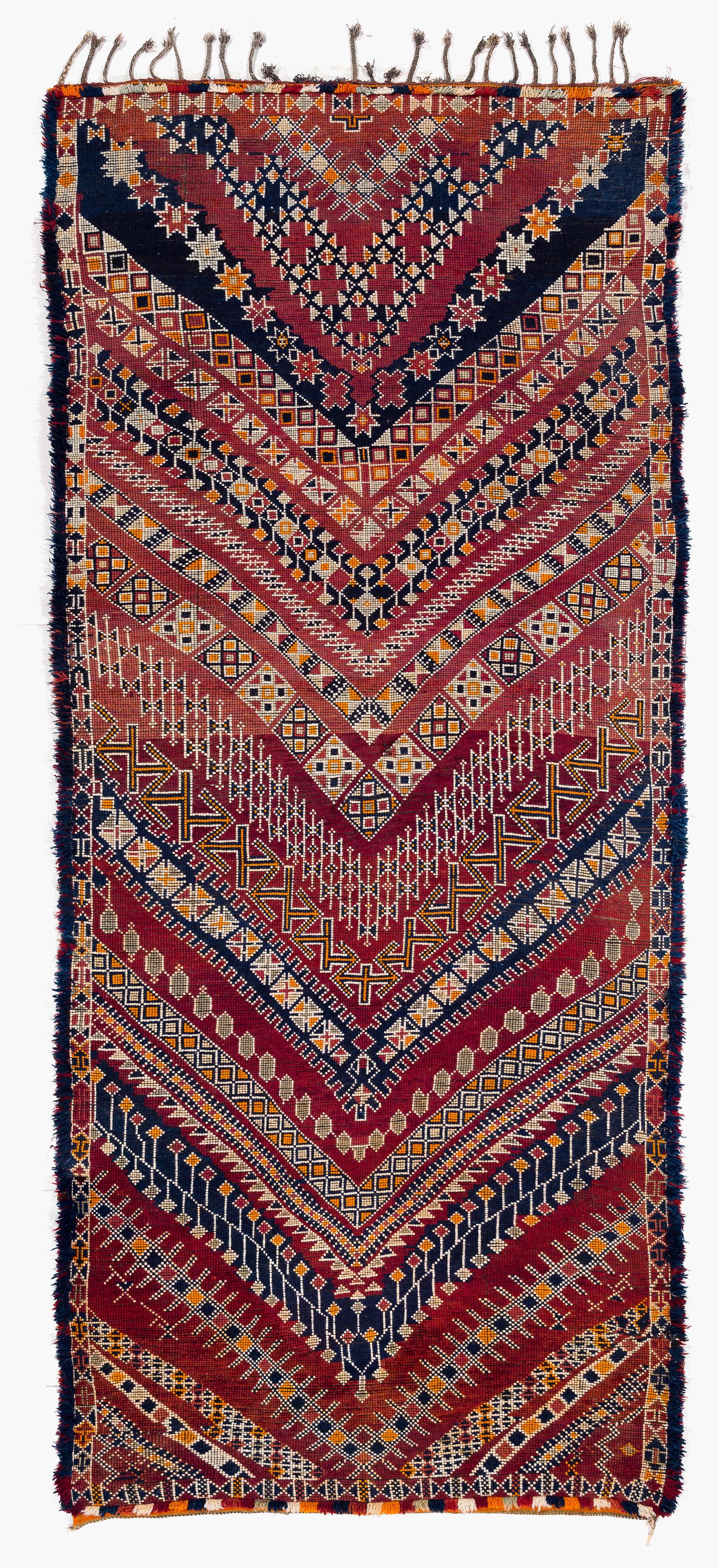 Ce tapis marocain ancien et vintage provient de la tribu des Beni Mguild du Moyen Atlas central, dans la région de la vallée du Guigou. Ce tapis présente une teinture magnifique et des couleurs riches et éclatantes. La palette de couleurs est