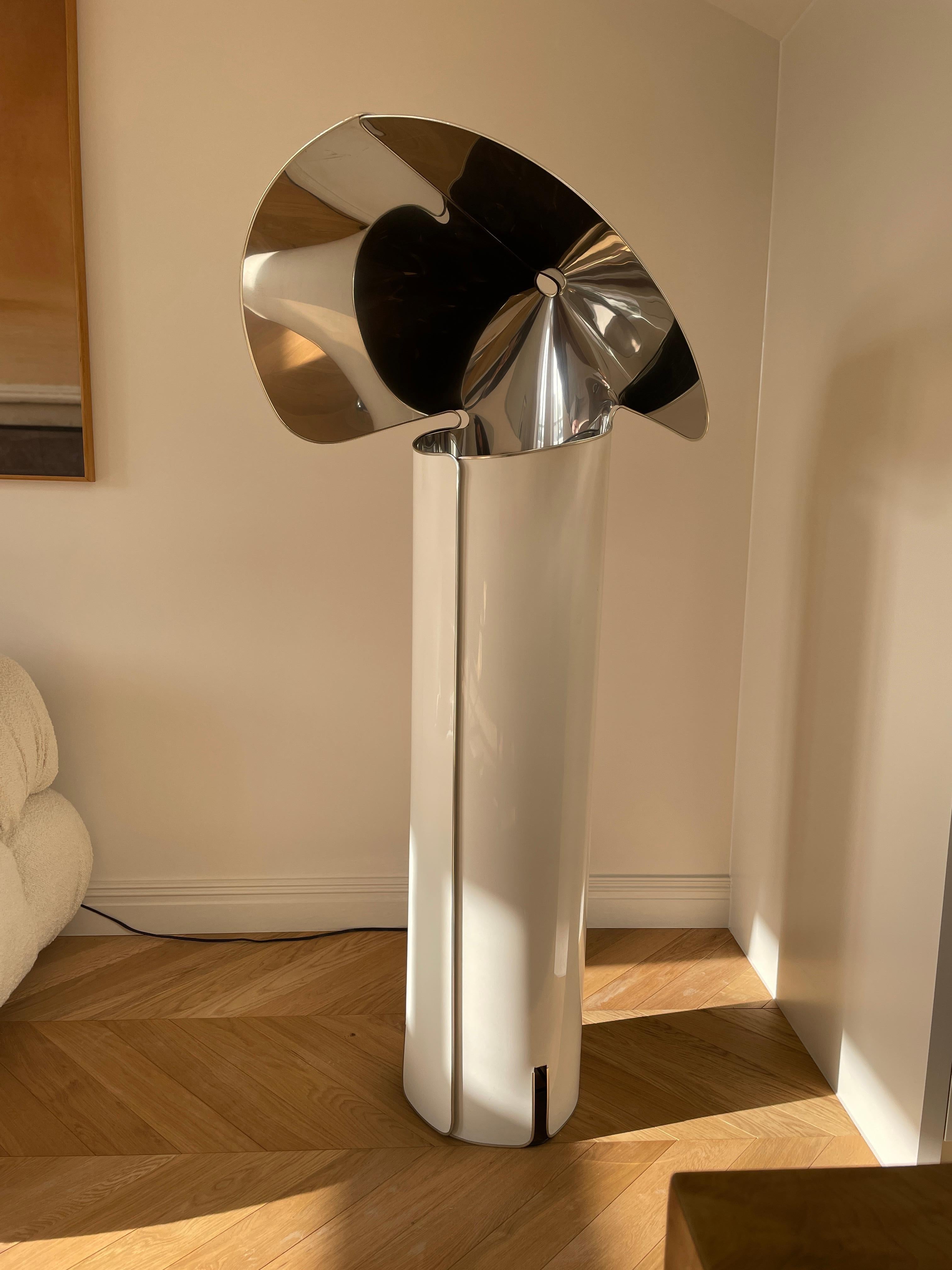 Height: 145cm

Designer: Mario Bellini
 Manufacturer: Flos
Date: 1960s

Materials: Lacquered metal

Description: This flatpackable design was made by Flos in 1969 and immediately became a design classic. Based loosely on a nun’s Habit, the lamp