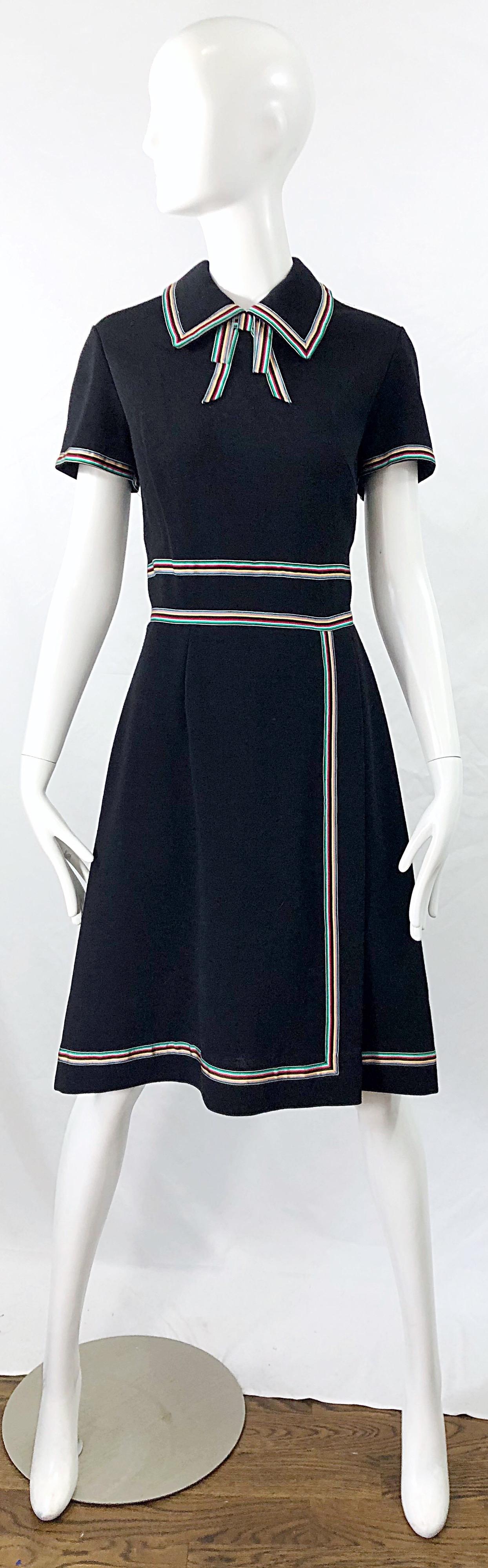 Chic 1960s black knit A-Line dress ! Features colorful ribbon details in green, yellow, red and black. Tailored bodice with an A-line forgiving skirt. Full metal zipper up the back with hook-and-eye closure. The perfect little black dress with that