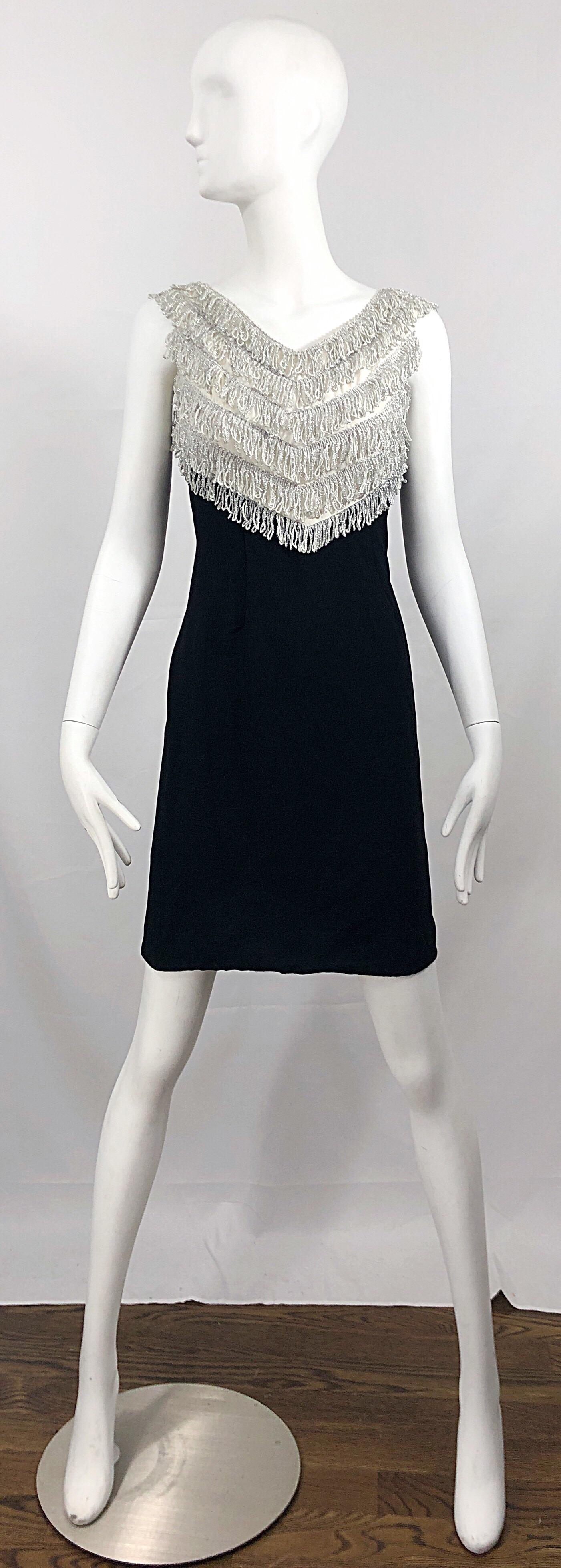 Chic 1960s black and metallic silver tassel fringed bodice sleeveless crepe shift dress! The perfect little black dress, with just the right amount of edge. Silver tassel fringe on the bodice. Flattering shift shape. Full metal zipper up the back
