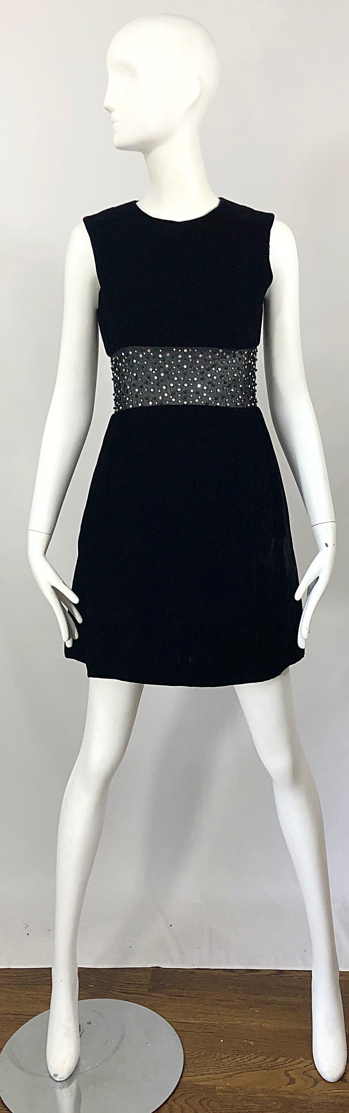 Schickes schwarzes Samtkleid mit A-Linien-Ausschnitt aus den 1960er Jahren! Aus weichem schwarzem Samt mit einem durchsichtigen schwarzen Netzausschnitt an der Taille. Über 100 handgenähte Strasssteine und Perlen auf der gesamten Verkleidung.