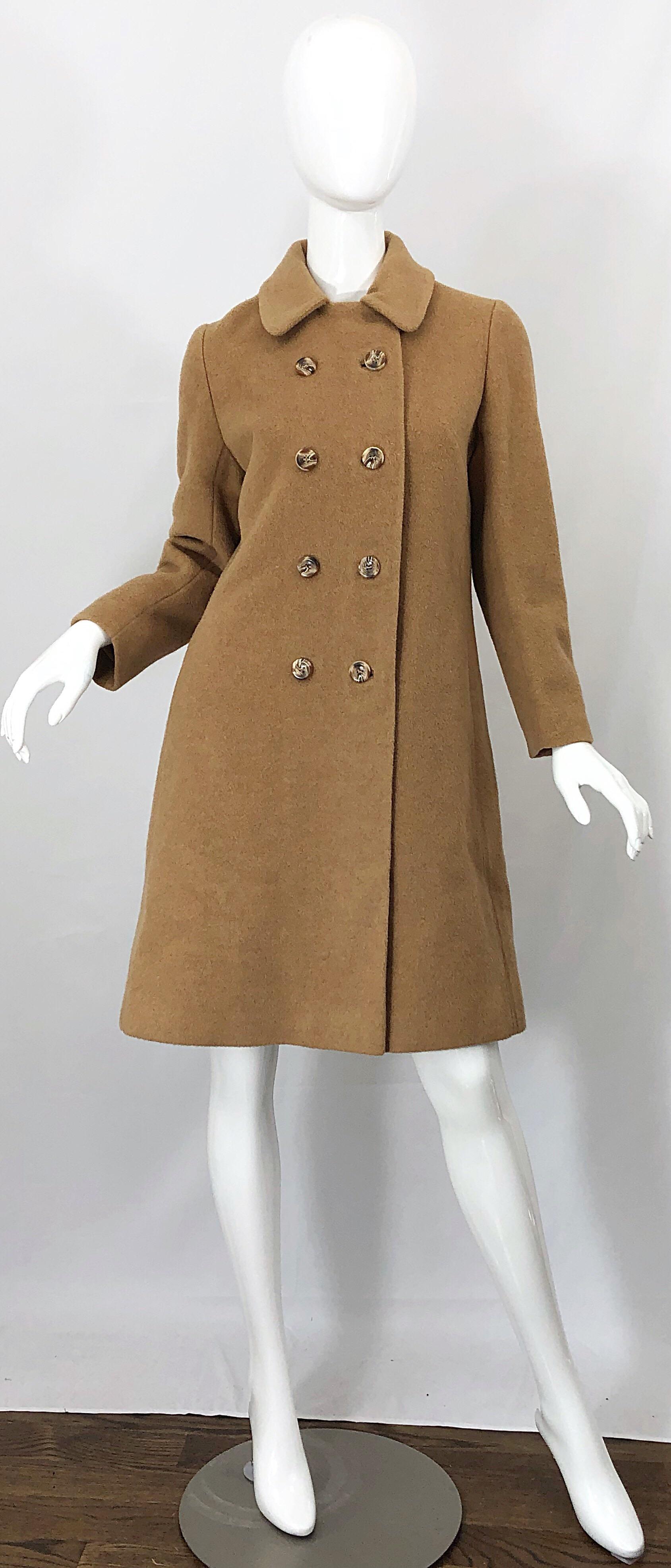 Chic timeless came / tan colored camels hair double breasted wool swing jacket ! Features soft and warm camels hair. Double breasted fit with 8 horn buttons up the front. Hidden button closure under left collar. Pockets at each side of the hips.