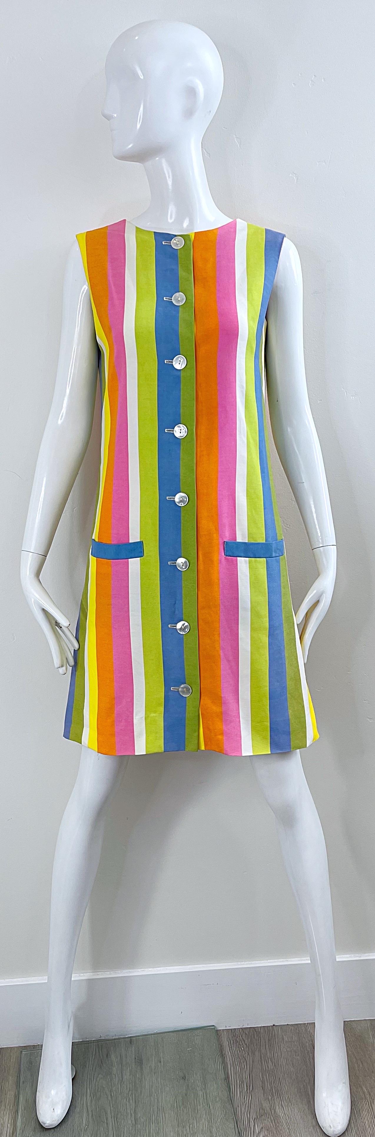 Chic 60s colorful striped shift dress ! Soft linen blended fabric in bold colors of pink, green, blue, yellow, orange and white. Flattering vertical stripes. Buttons up the front. Pockets at each side of the waist. 
Pair with wedges, flats or