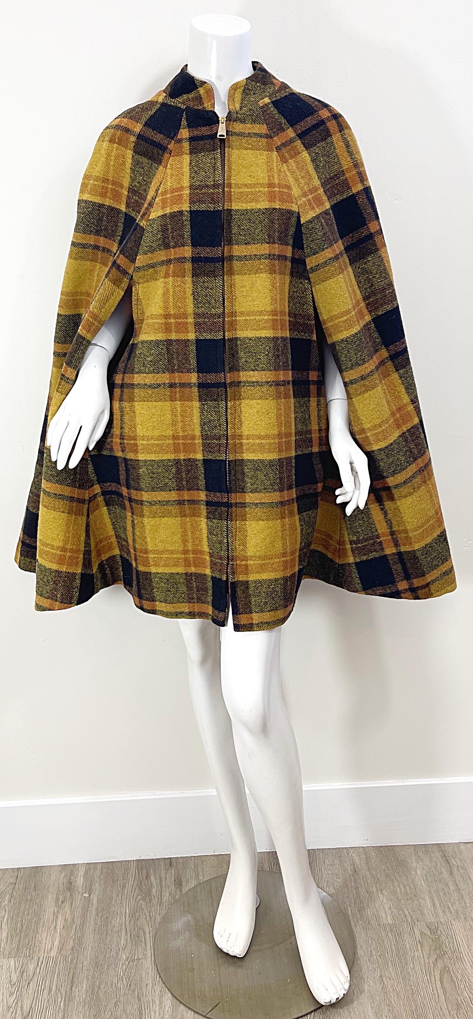 Chic mid 60s plaid wool cape ! Features warm hues of burnt orange, marigold yellow and black colors throughout. Full metal zipper up the front. Easy, timeless and effortless. In great condition
One Size Fits All 