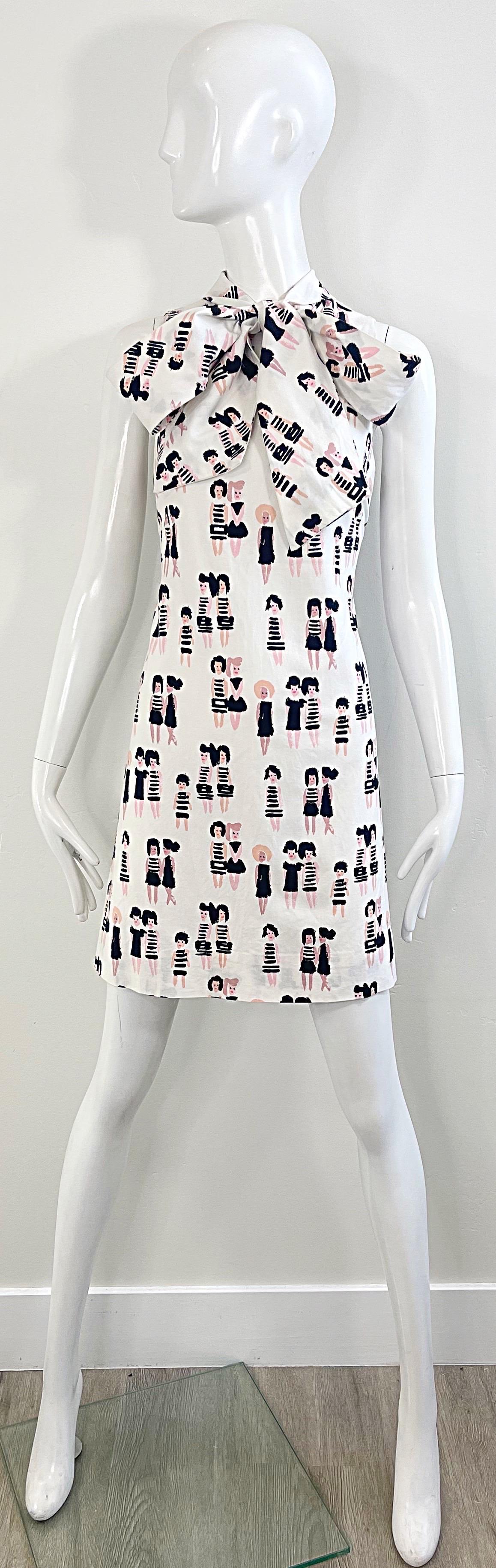Amazing 1990s novelty print cotton dress ! Features 1960s mod French girls printed throughout. Ties into a bow at center neck. Hidden zipper up the back with hook-and-eye closures. Great for any day or evening event. Pair with wedges, flats or