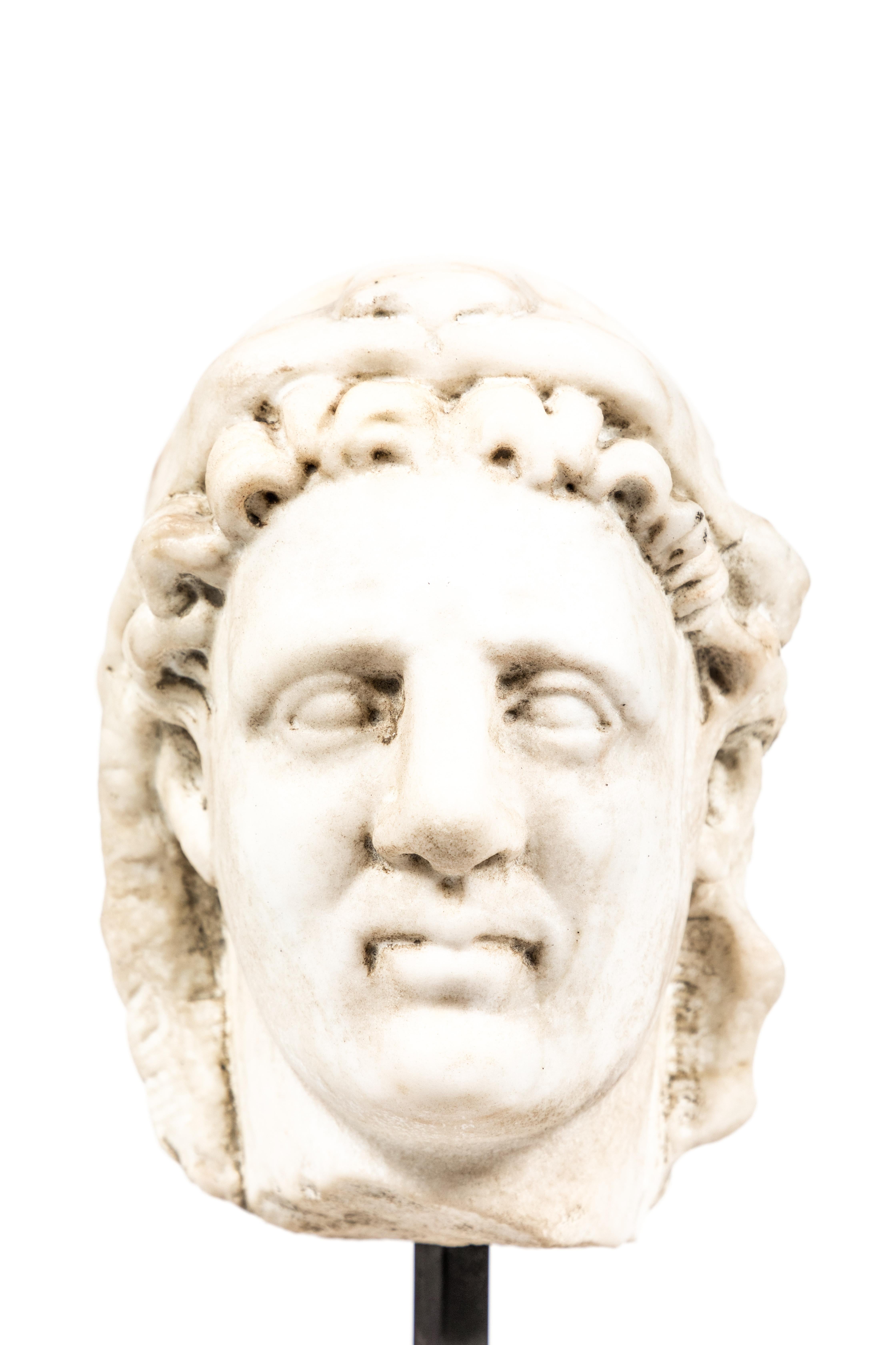 Timeless, Italian, Roman-style carved marble bust of a man in a lion’s-pelt hood. Mounted on a custom, marble base.