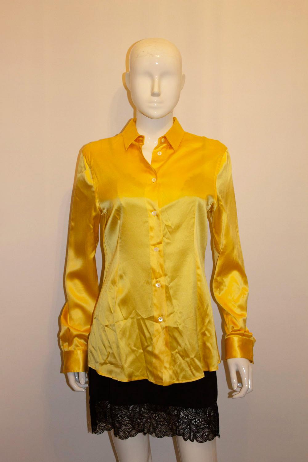  A chic silk blouse by Dolce and Gabbana in a  stunning shade of yellow. The  blouse has a button front opening, pleat at the back and single button cuffs. 96% silk, 4% spandex. Made in Italy 
Size 44 . Measurements: Bust 36'', length 28''