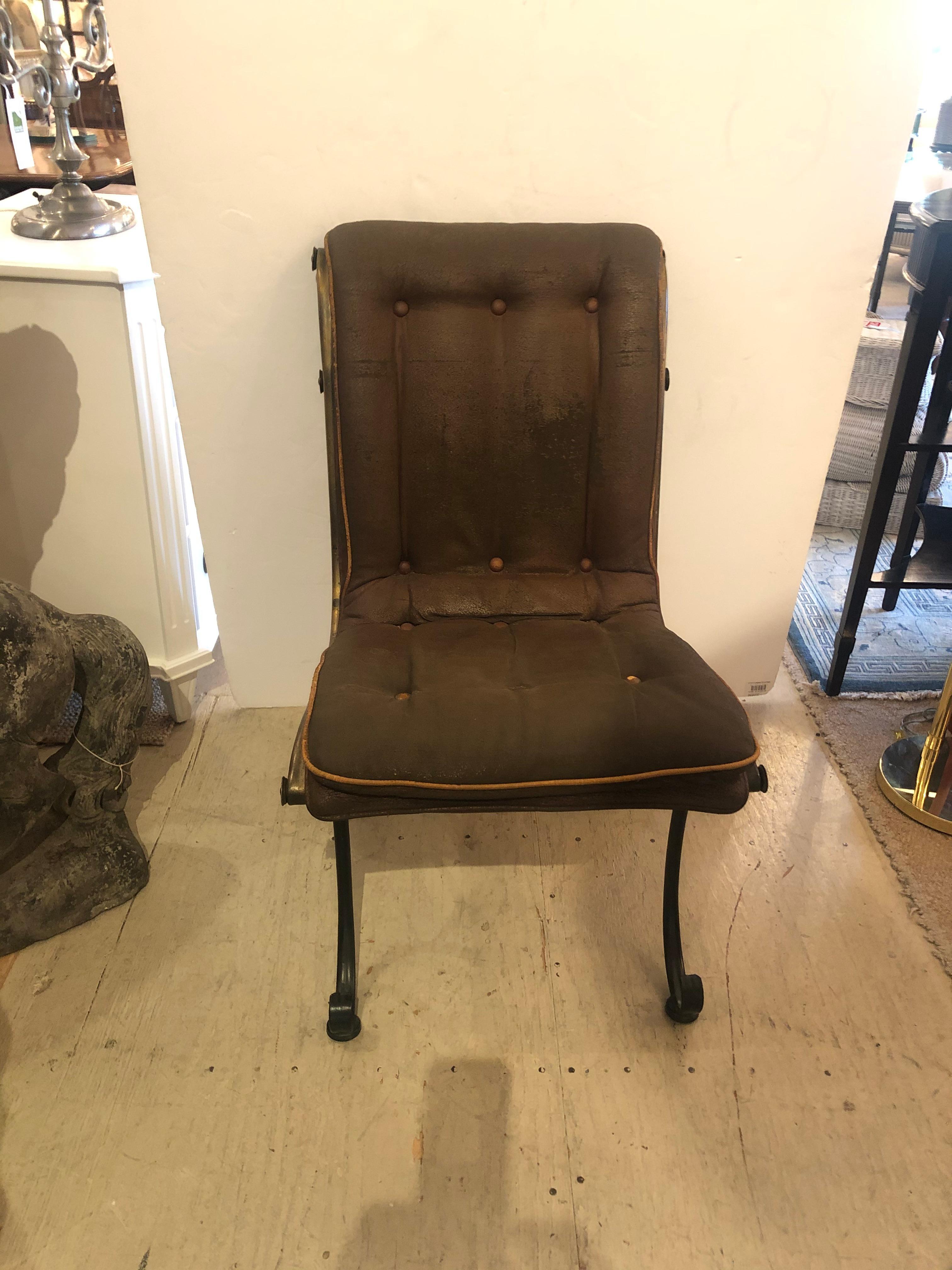 Wonderful turn of the century French occasional chair, remarkably comfortable and oozing with character, having heavy curlicue iron and brass frame and original handsome distressed leather upholstery.

 