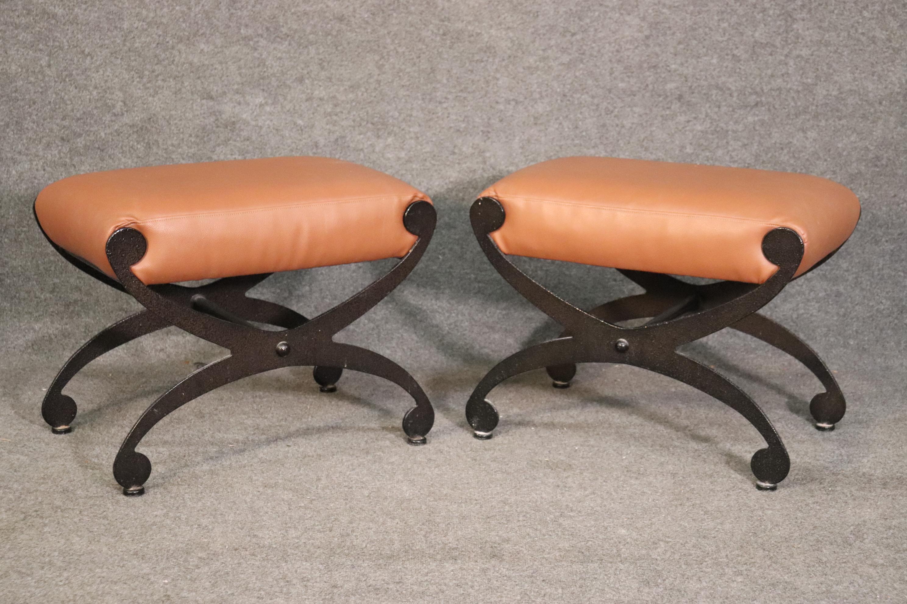 These beautiful leather upholstered wrought iron benches have that great cerule or maybe an x shape. They are in very good condition with minor signs of age and wear but really nothing to mention. The look is unique and chic, very clean lines and