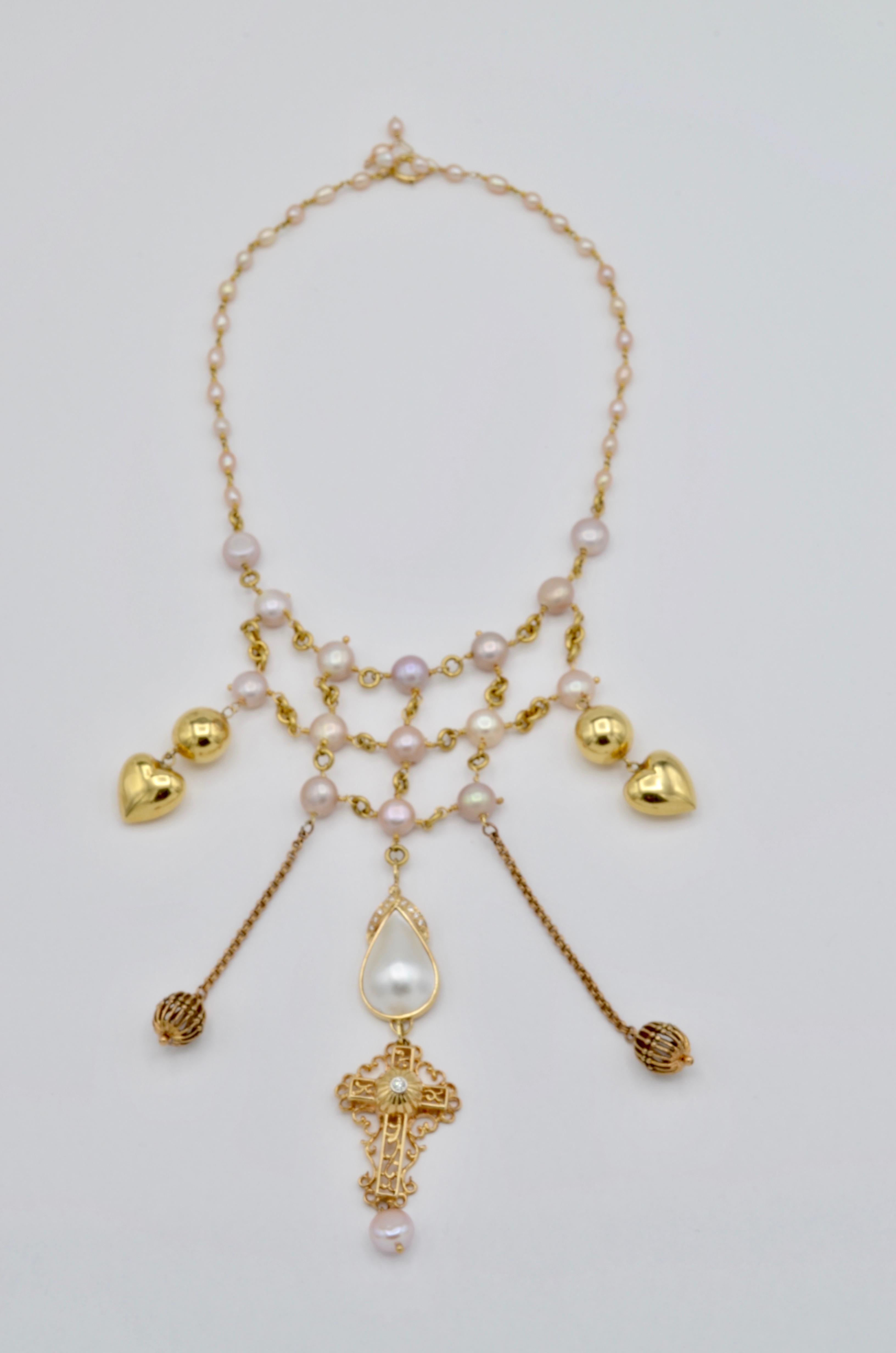 Pink fresh water pearls, a tear drop mabe pearl, gold hearts, diamonds, and a cross create this fashionable statement piece. All 14K yellow gold in a Versace-like style, this statement piece is made to dazzle. Chic, glamorous, and absolutely