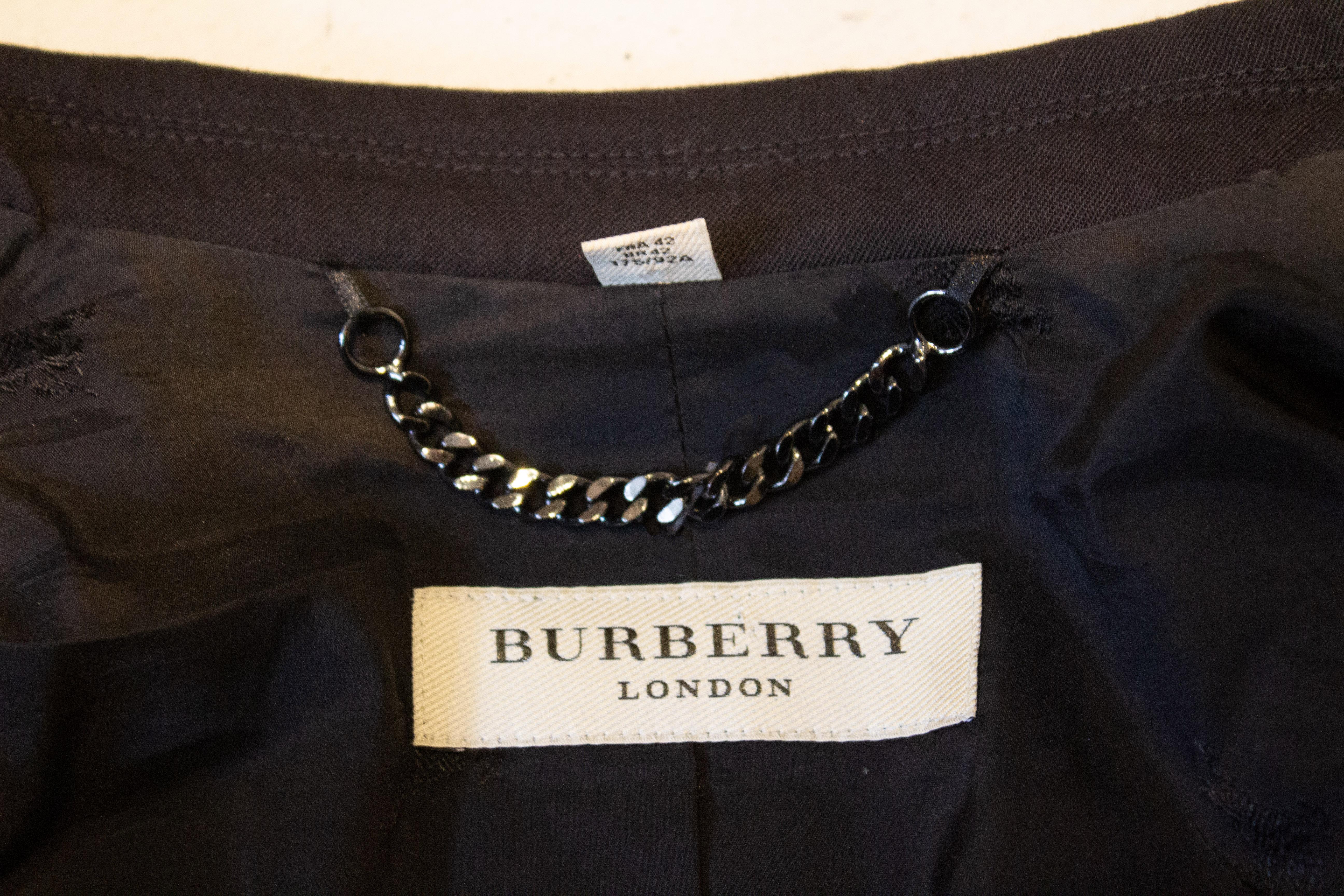 A great jacket by Burberry with interesting detail at the back.  The wool jacket has noe breat pocket , two faux pockets at hip leval  and gathering at the back. It is marked a size 12 , 175/92A.  It will fit a bust up to 40'',length 24''.