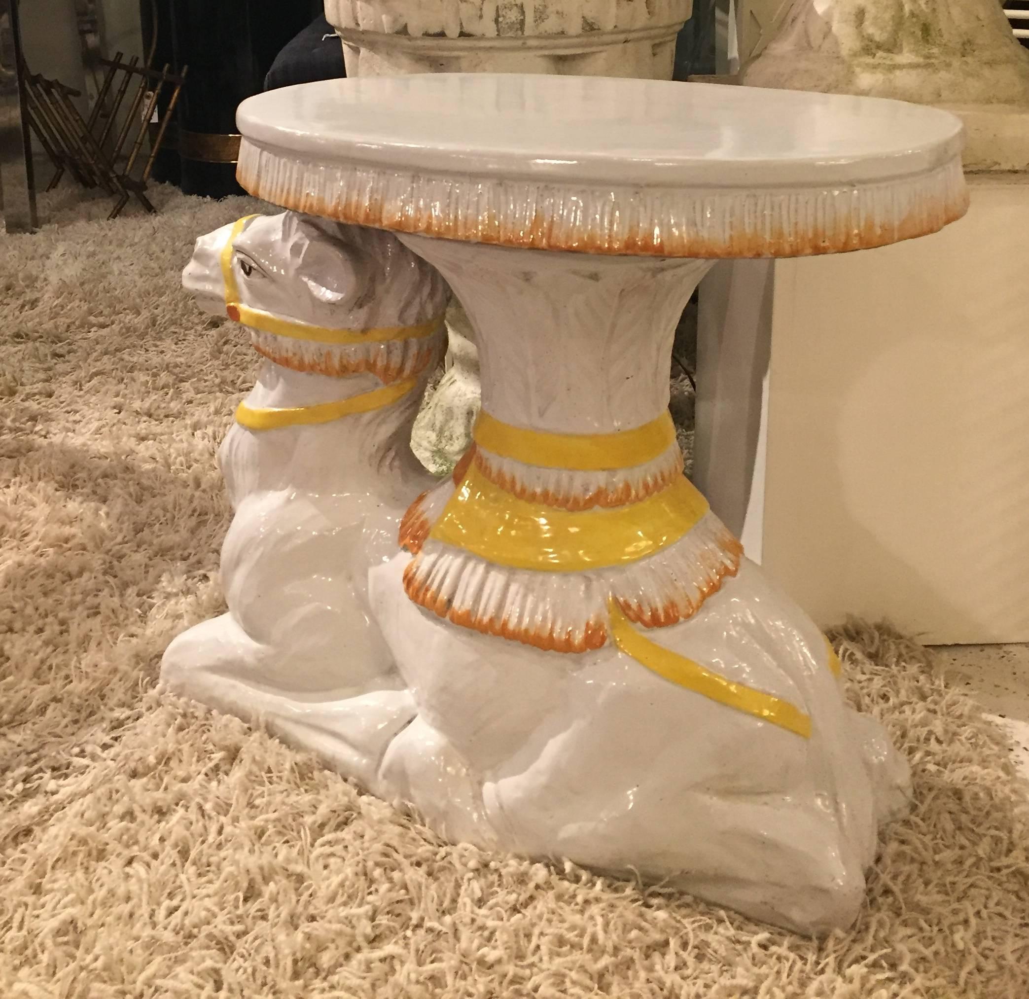 Fabulous Tony Duquette style chic side table or drinks table garden seat in the shape of a reclining camel. Glazed and painted terra cotta.
Measure: Top is 21 L x 12.5 D
Base 23 L x 10 W.