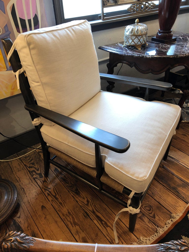 Large comfortable and classic walnut ladder back lounge chair having arms, rush seat, and new white heavy woven, top of the line upholstered cushions. Handsome ties in all cushion corners. Only one available.
Measures: Arm height 24.