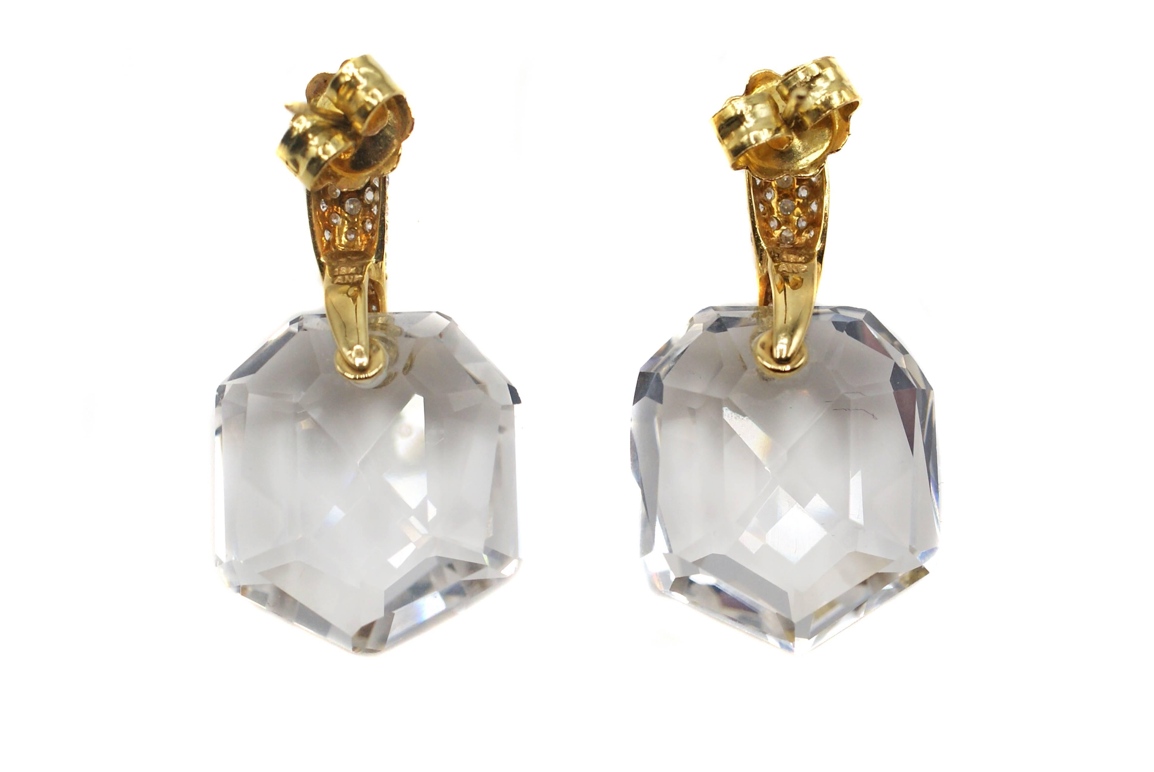 These chic and elegant earrings have been masterfully designed and hand-crafted out of 18 karat yellow gold. The tops have been pave set with bright white and sparkling round brilliant cut diamonds. Extending from these are 2 clear Rock Crystals