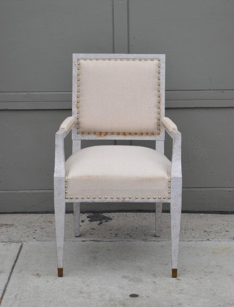 Chic French 40's armchair in the style of Andre Arbus. Brass sabots. White washed frame, natural linen upholstery.