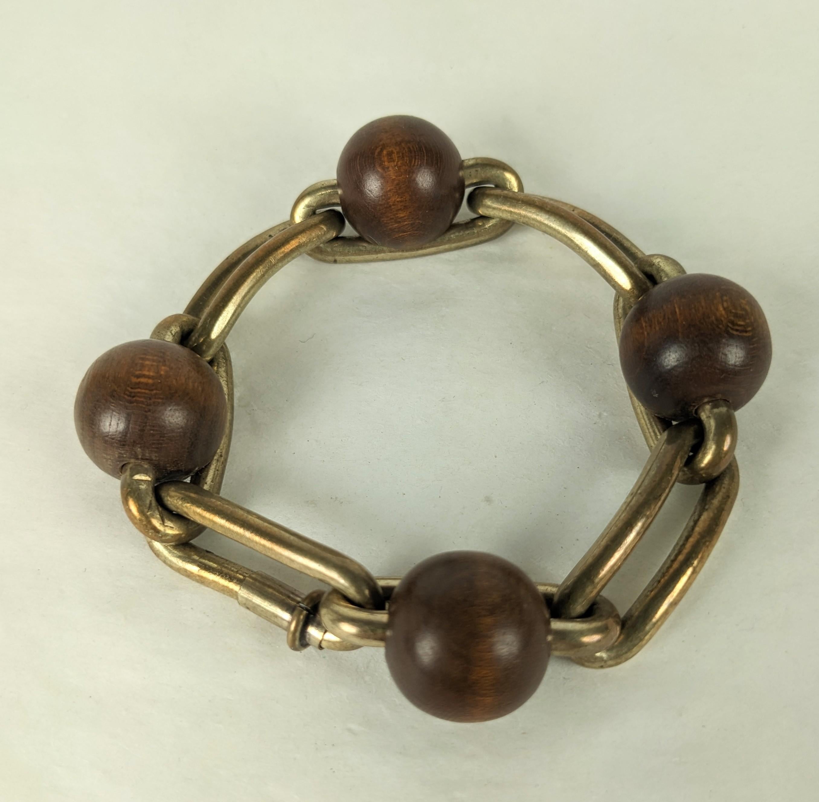 Hermes Style French Art Deco link bracelet circa 1930. Of large brass paper clip elongated machine age oval links, mounted with four exotic wood beads. Unique hidden link spring clasp. Good Condition, Fits Very Small size wrist. L 7.25 x W