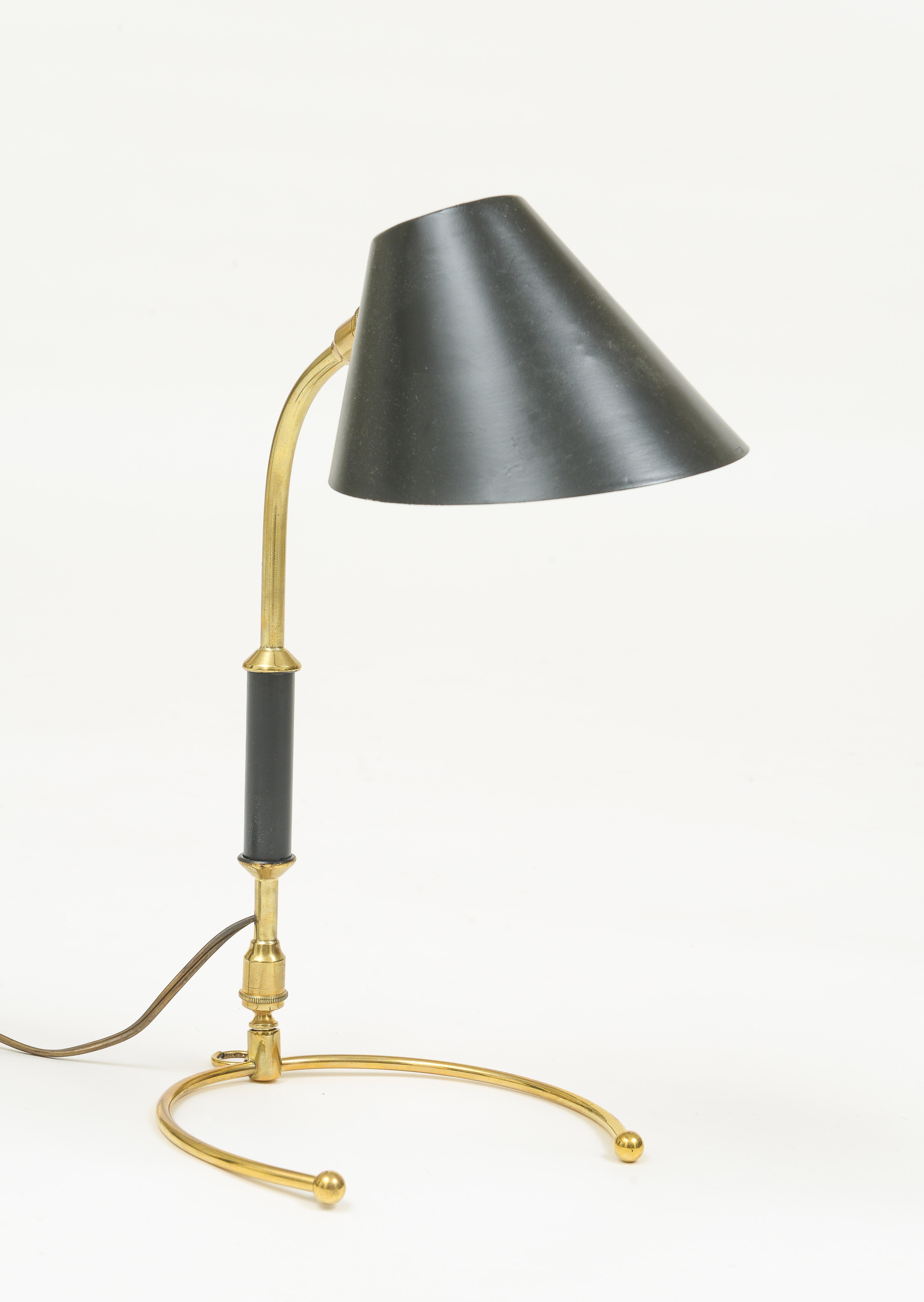 Black and brass Robert Mathieu Lunel articulating desk lamp with beautiufl patina and horseshoe base. The head shade swivels in all directions. The base all has a swiveling mechanism. 
Chic and handsome. Beautiful condition.