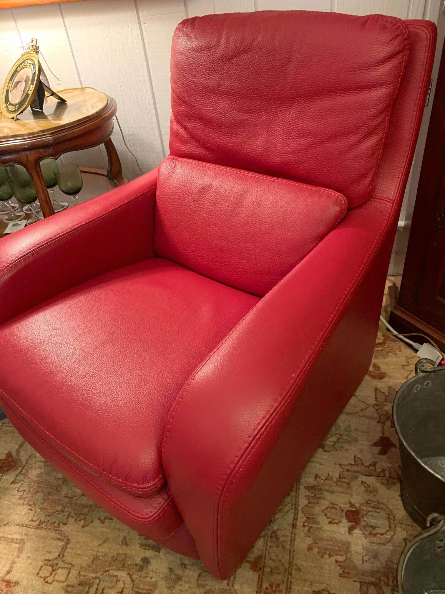 A super chic Roche Bobois Italian buttery leather swivel club chair that has wheels on feet and sensational rasberry red color.