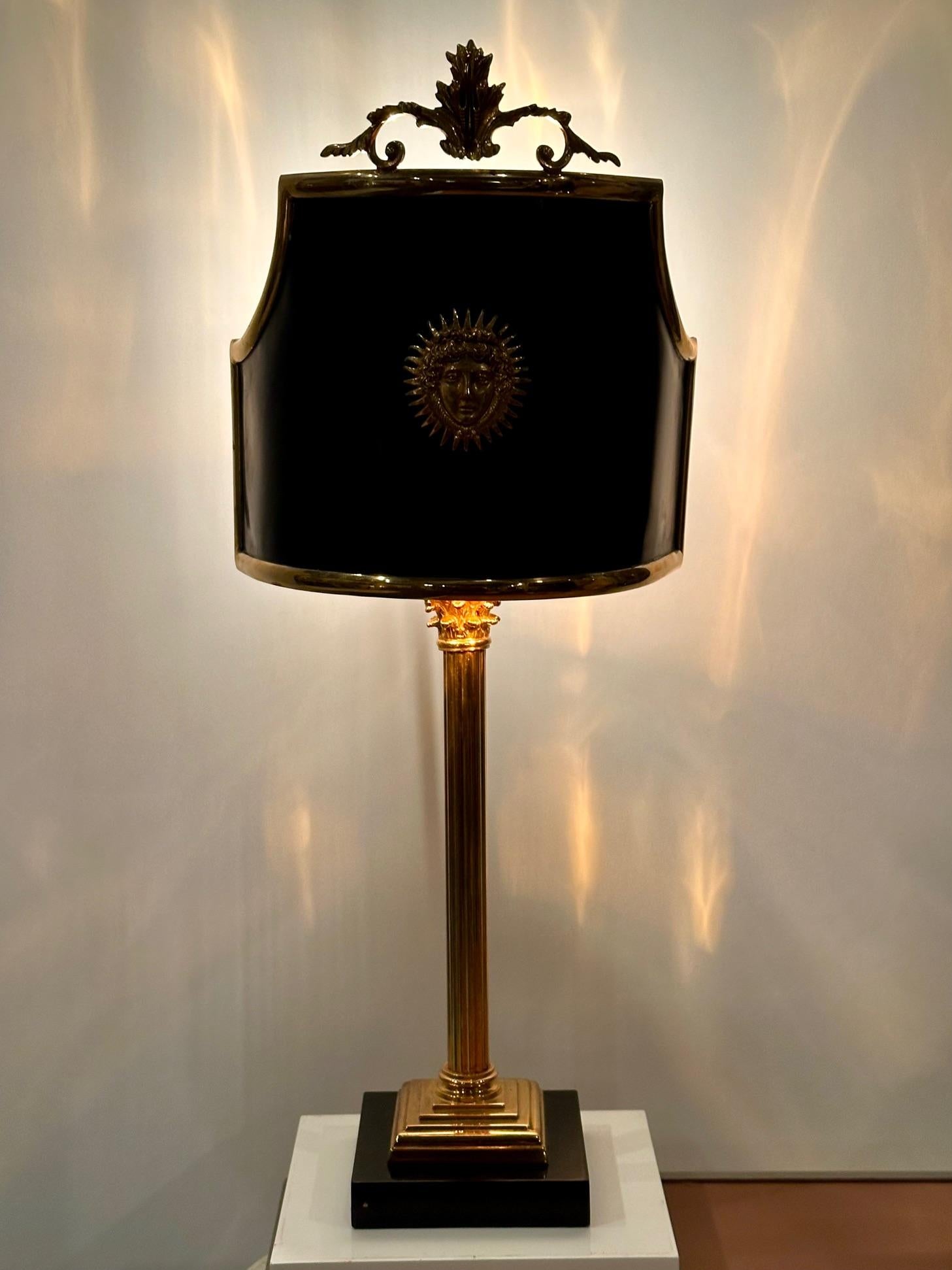 Stunning black and gold Maison Jansen gilt bronze and black ebonized table lamp having columnar form, fabulously shaped metal shade with starburst decoration on the front.  Oozes elegance.