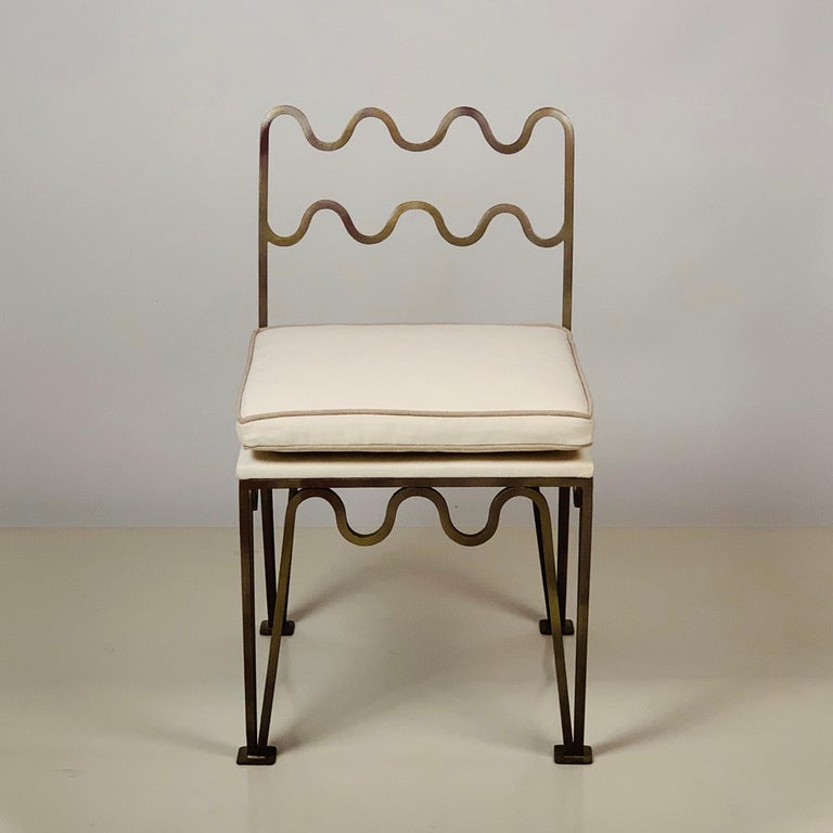 Chic undulating 'Méandre' side chairs by Design Frères.

Hand applied gilt bronze patina over steel frame. Natural linen upholstered cushion.

Inspired by the timeless aesthetic of French modern design, this chair from our exclusive Design