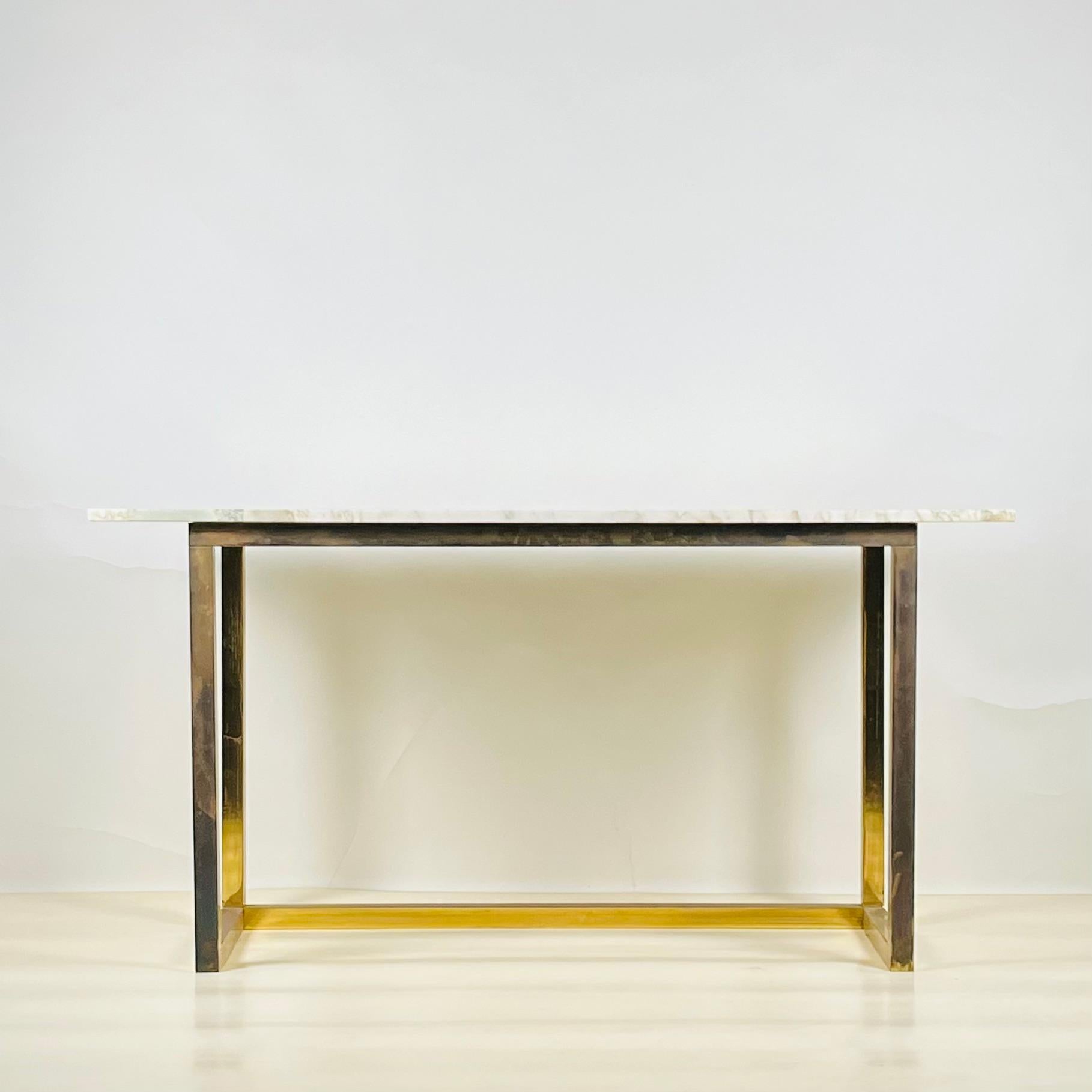 Minimalist patinated brass and marble console or library table.

Chic and understated.

Footprint of the base: 47.5 in. wide x 18 in. deep.